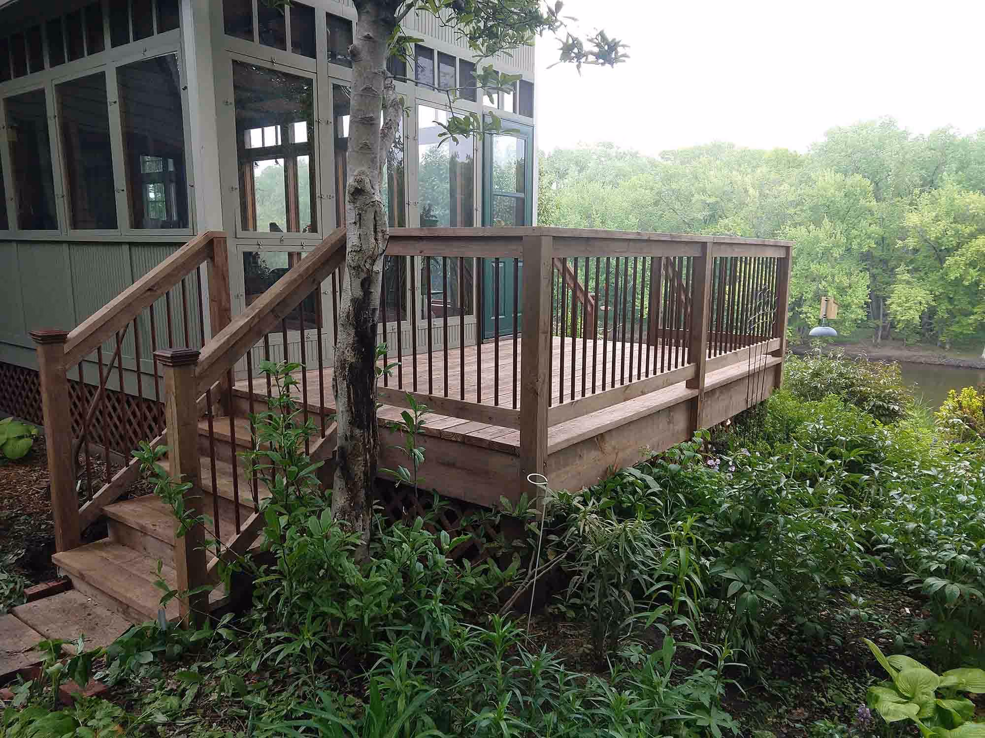 Wooden deck with stairs overlooking greenery