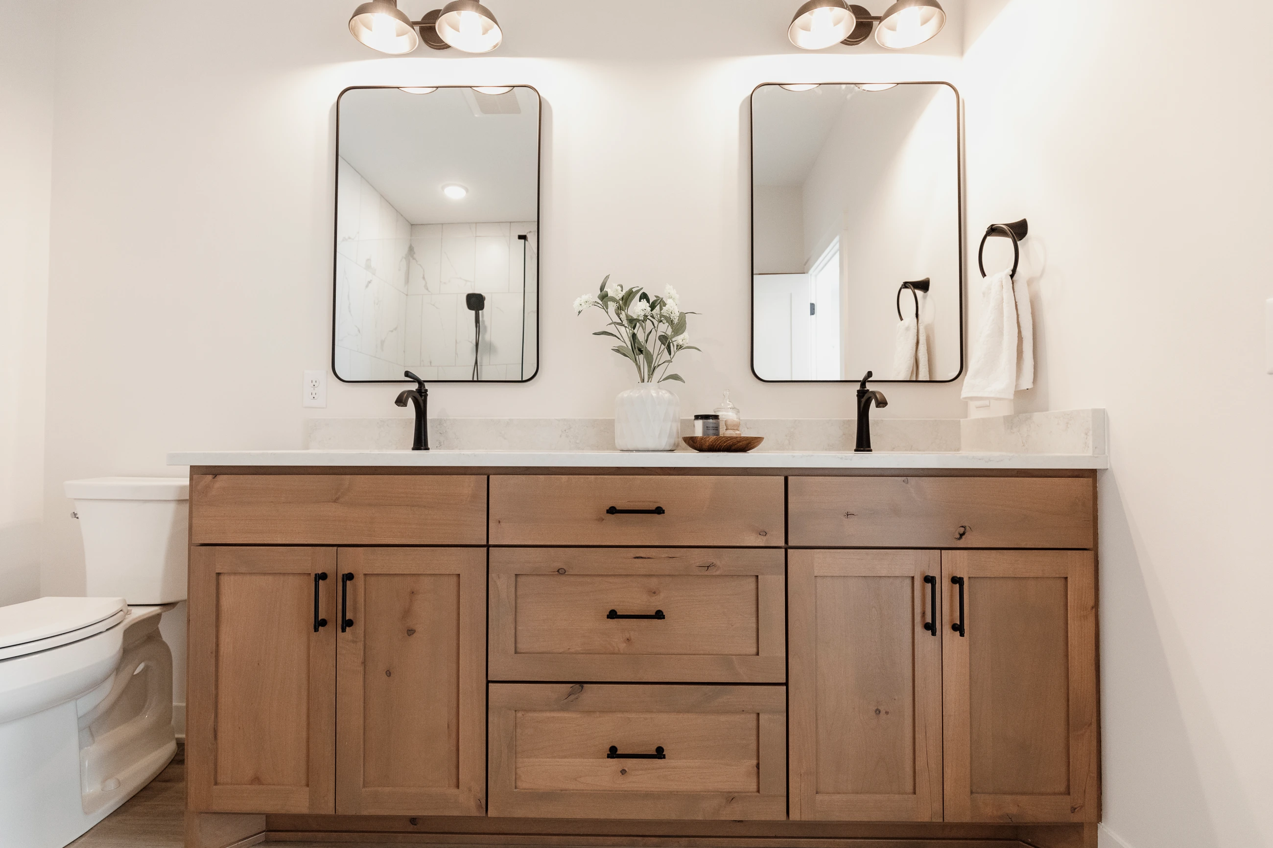Double-sink bathroom vanity with mirrors and wood cabinets
