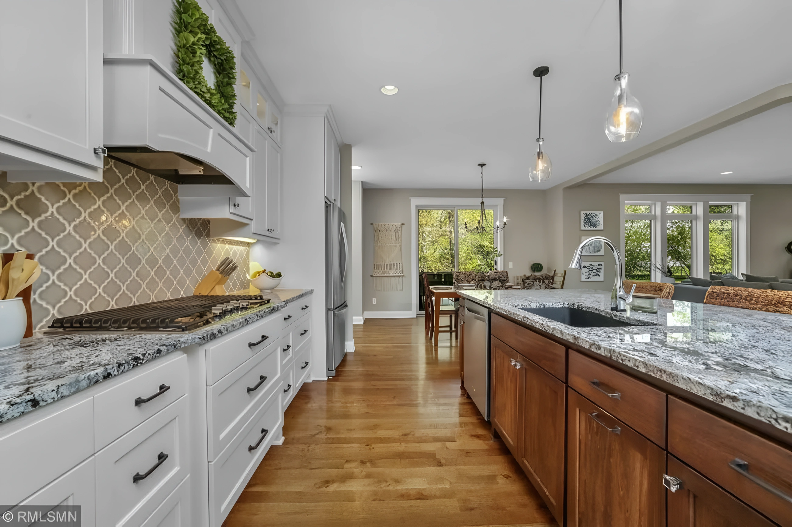 Bright white kitchen with long island and pendant lights