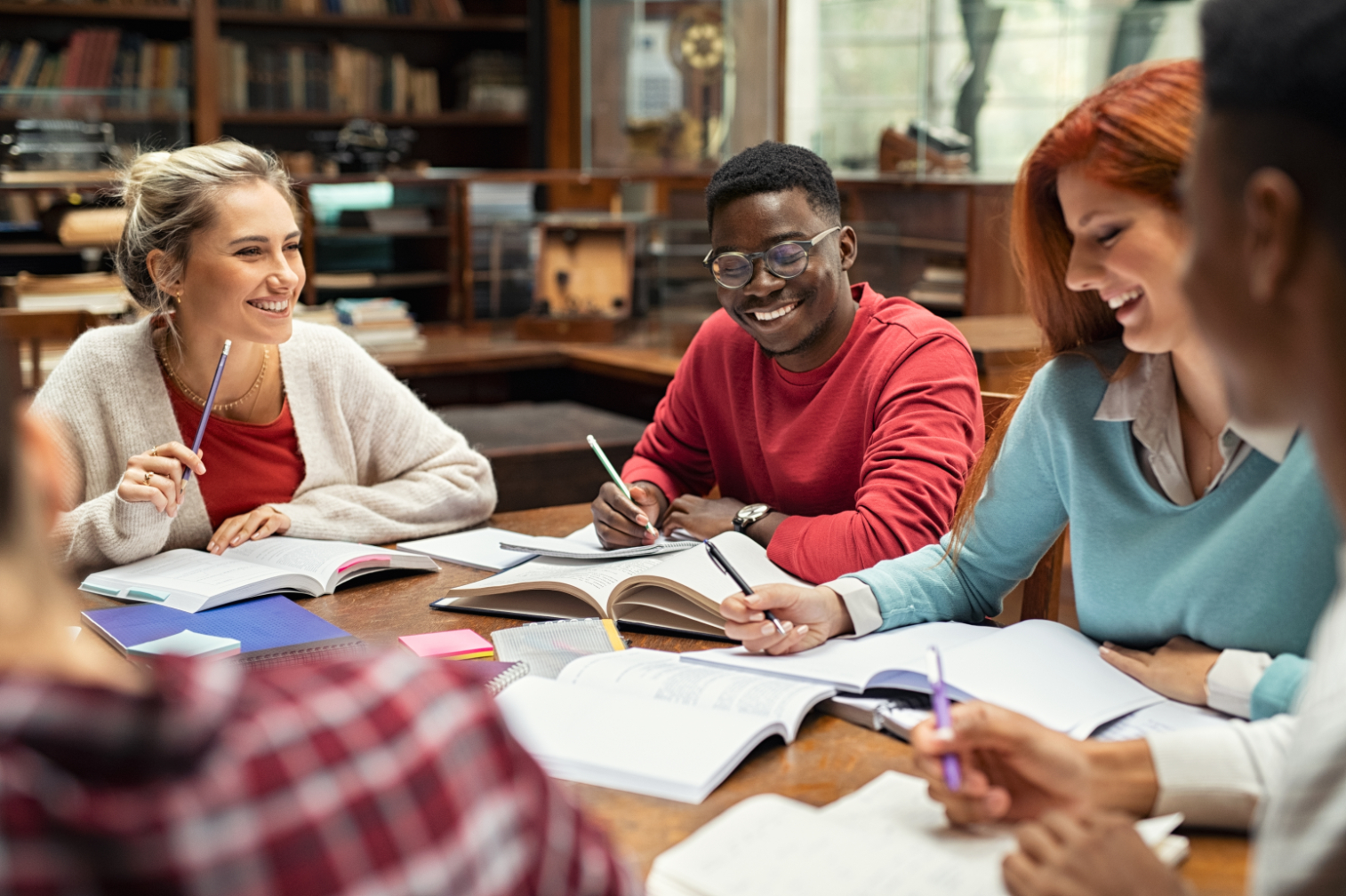 Group of people in library sitting at table smiling stock image