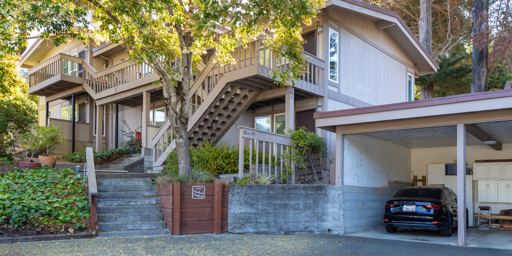 South Knoll exterior surrounded by trees featuring covered parking area with car