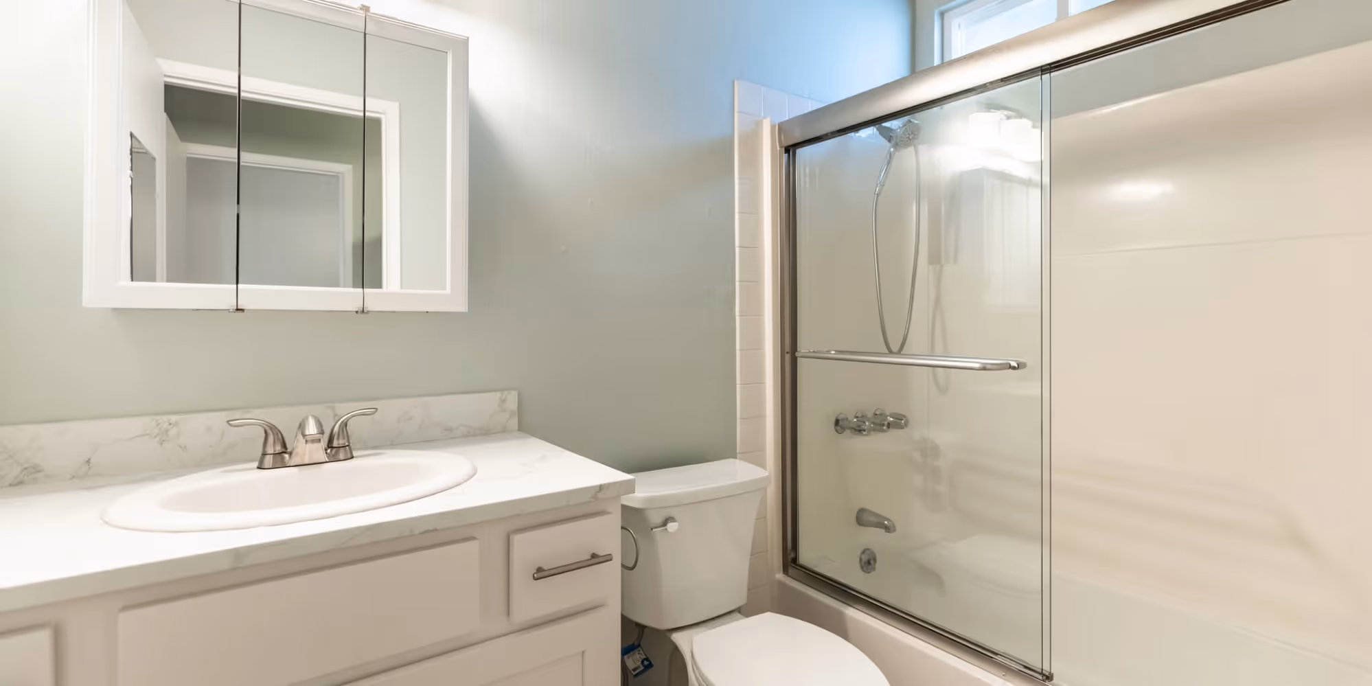 Bathroom with white cabinets and shower tub combo