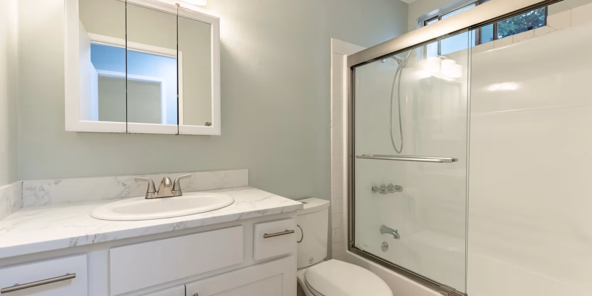 Bathroom with white cabinets and shower tub combo