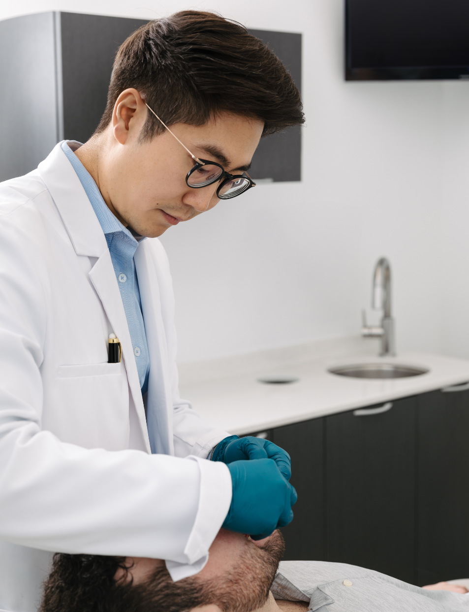 Dr. Chris Kim performing a dental procedure at Livewell Dental
