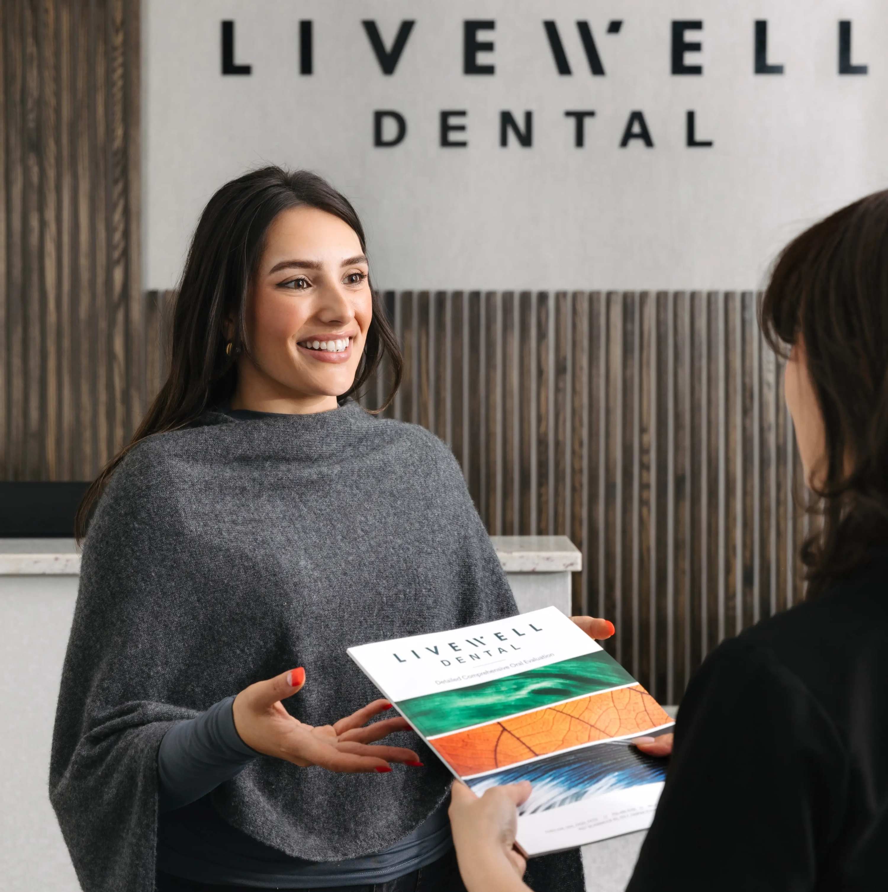 Livewell Dental team member greeting a new patient at the front desk