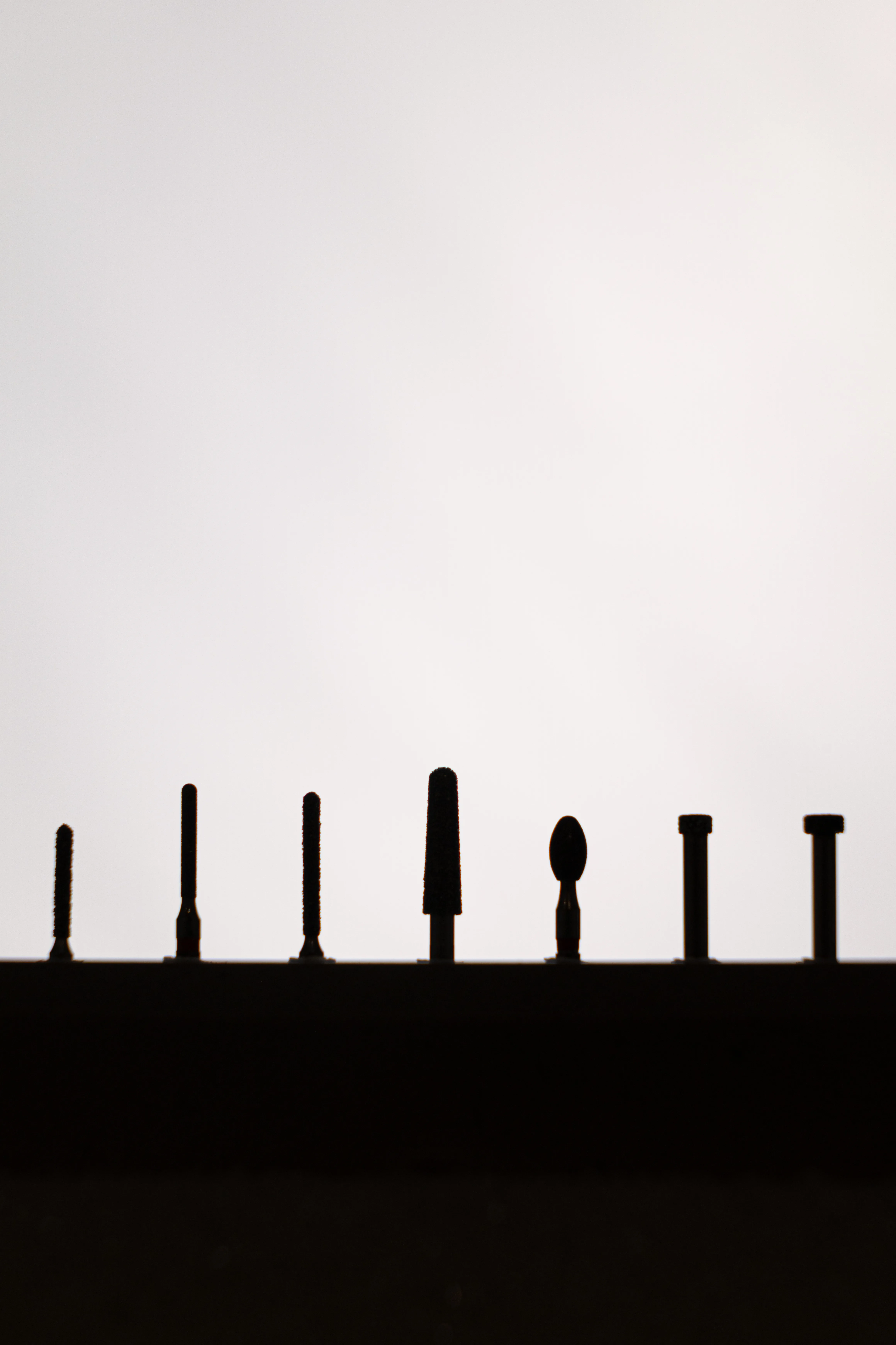 Backlit silhouette of dental polishing burs in a row