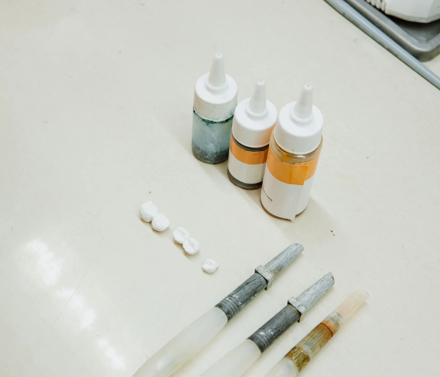 Porcelain staining liquids and brushes on a dental laboratory bench