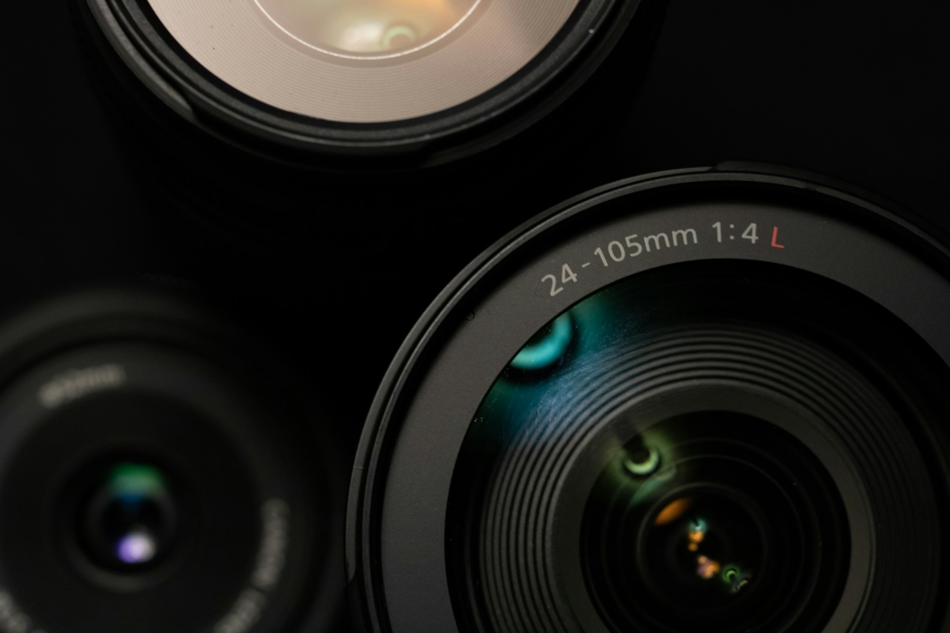Close-up of a 24-105mm 1:4 L camera lens with reflections on the glass surface.