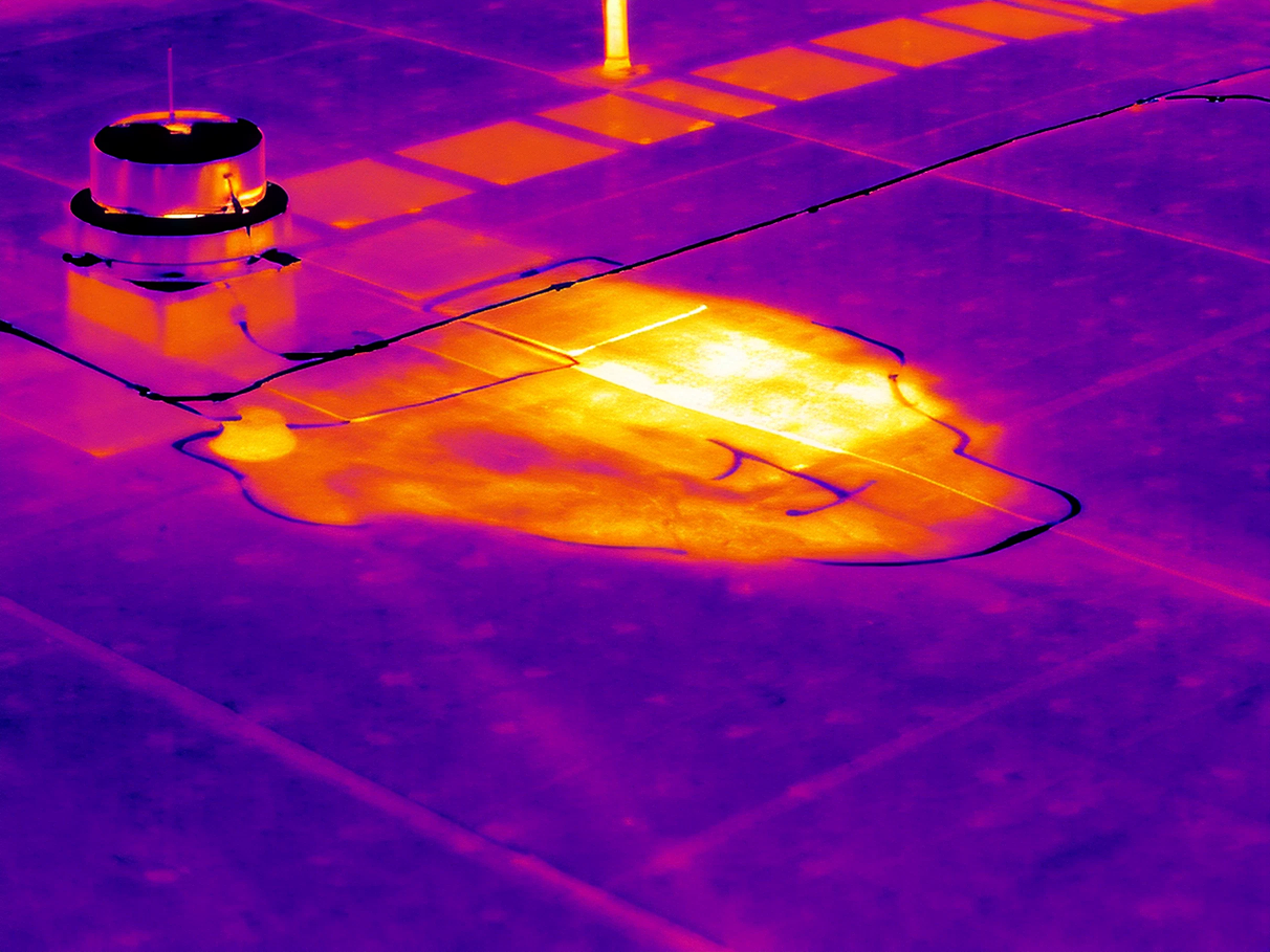 Thermal image showing a hot area on a tiled floor near a vent or pipe.
