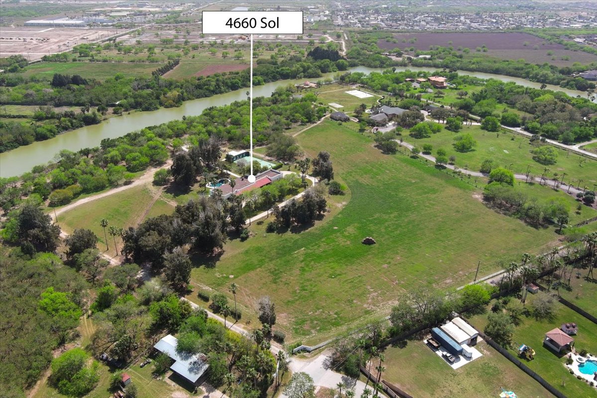 Aerial view of a large green property with scattered trees and buildings next to a river, highlighting the location marked as 4660 Sol.