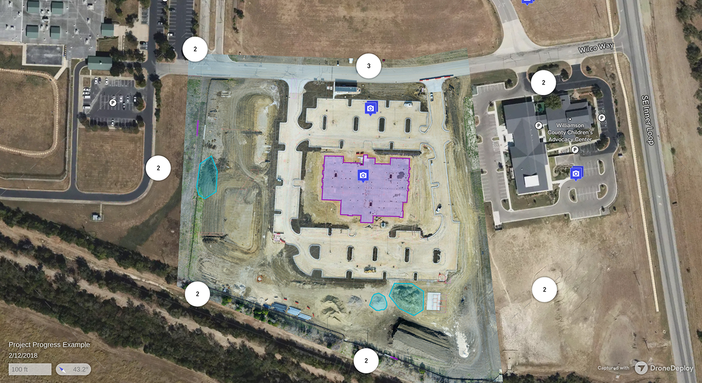 Aerial view of a construction site with a central building marked in purple, surrounding parking lots, dirt areas, and adjacent buildings including Williamson County Children’s Advocacy Center.