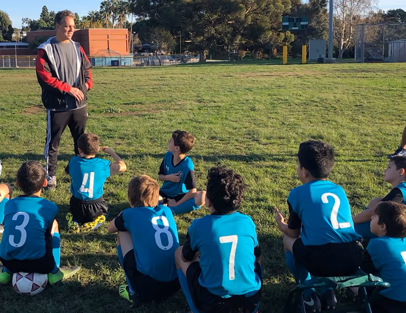 Adam entrenando a uno de sus muchos equipos de la AYSO