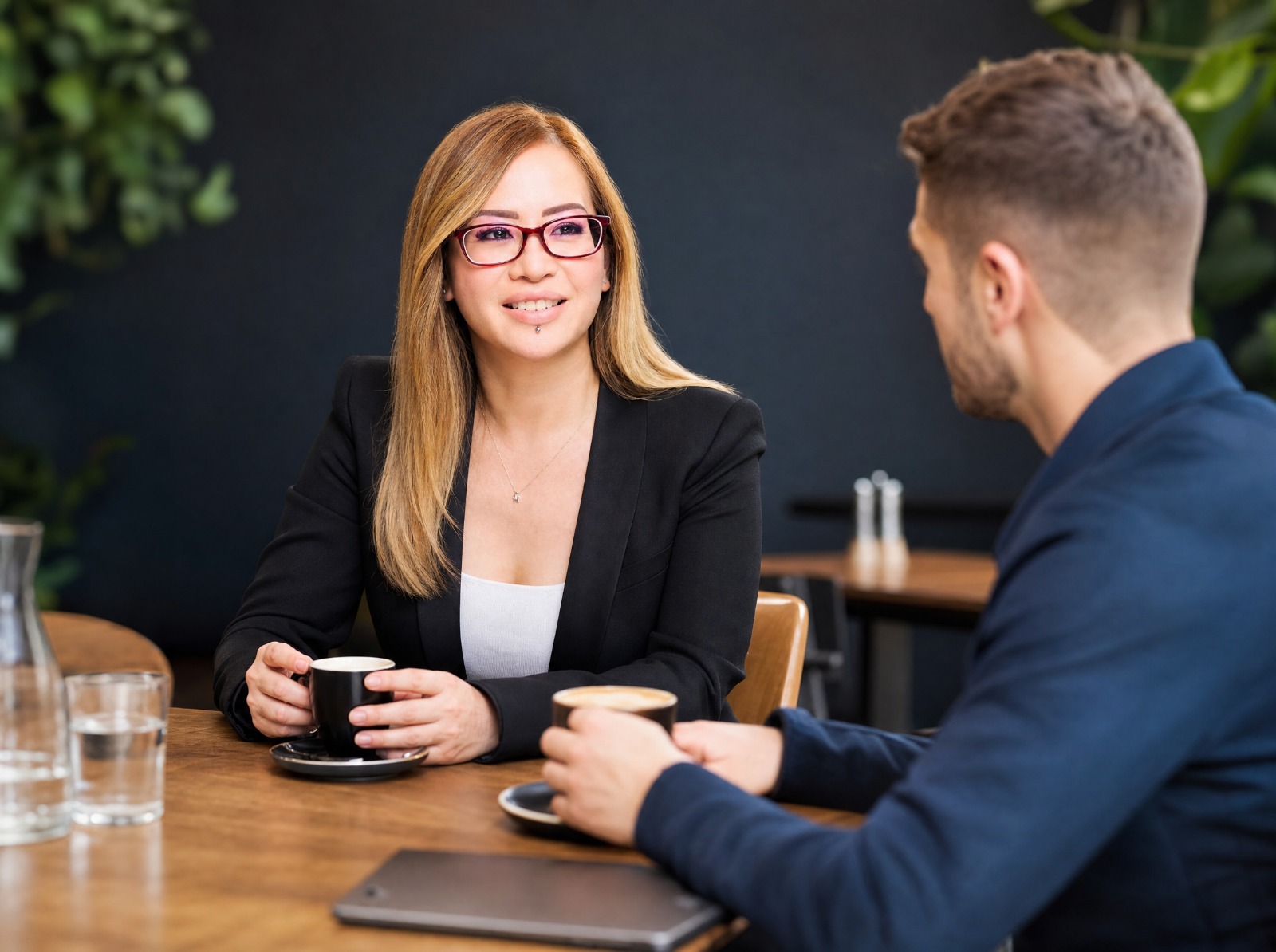 Bookkeeper meeting one-on-one with a client over coffee at a table.