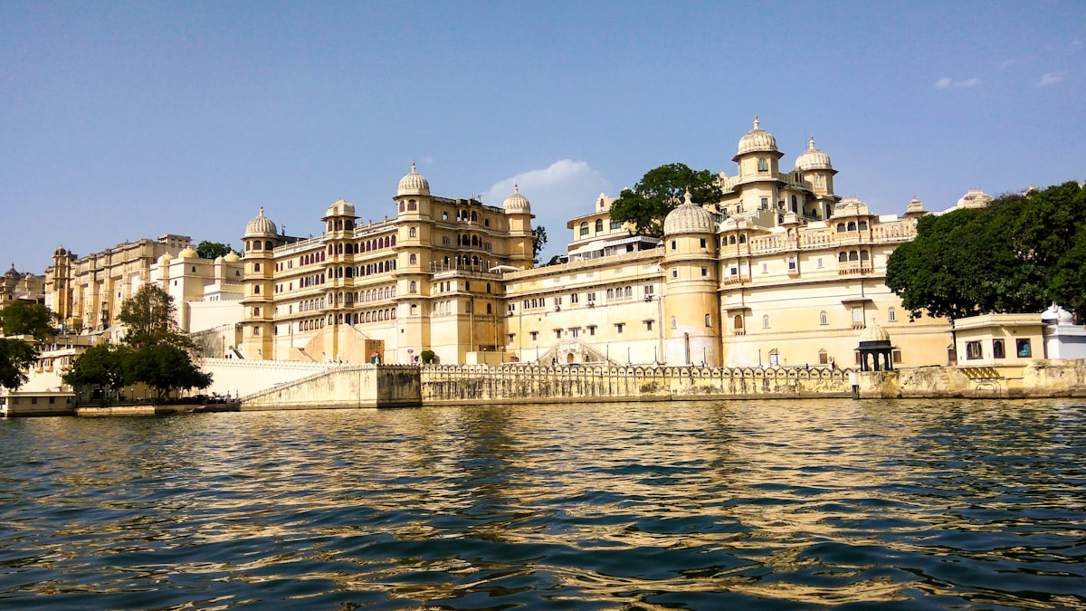 White luxury hotel building reflected in calm lake water