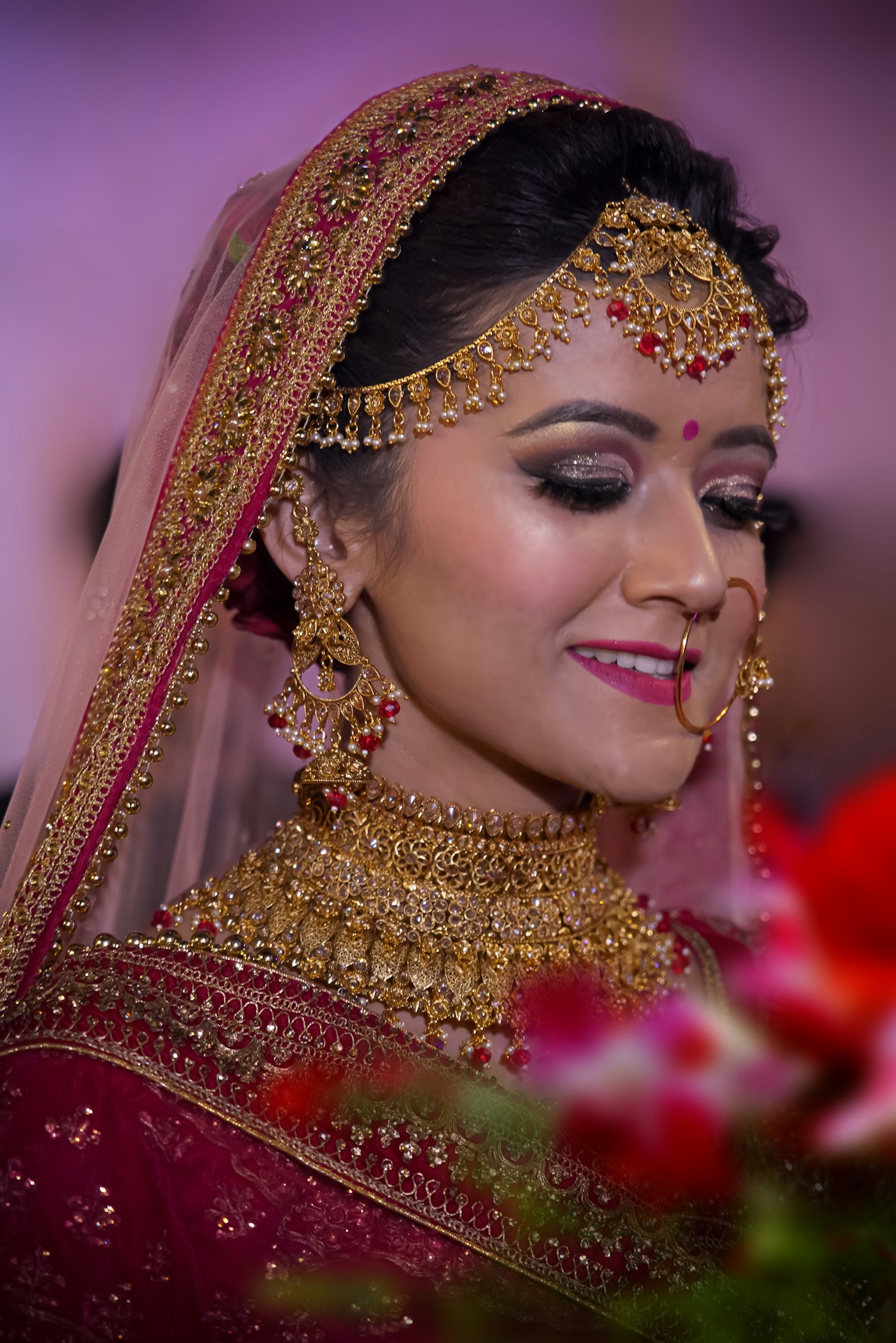Indian bride in traditional red bridal attire adorned with Polki gold jewellery and uncut diamonds