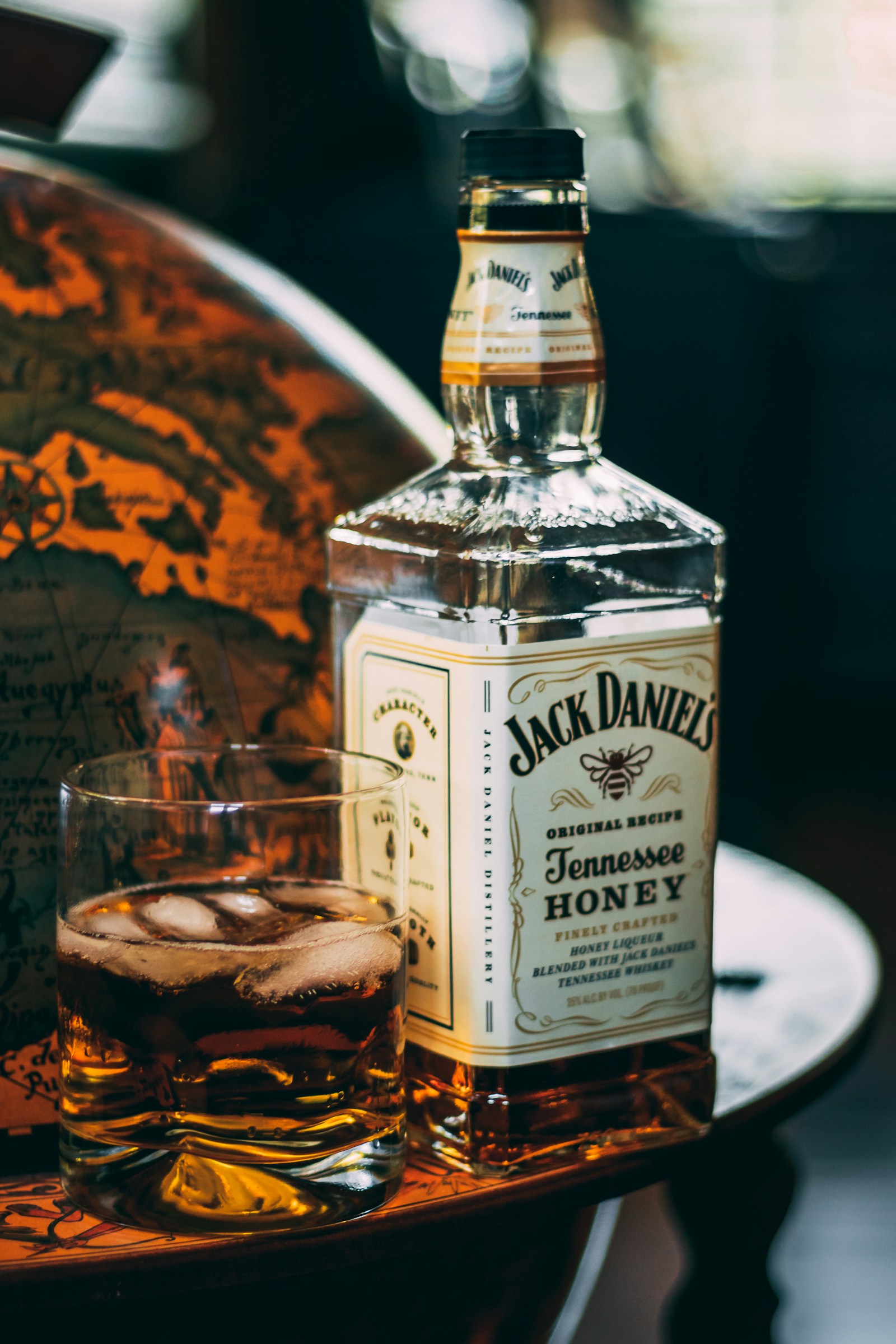 Premium whisky poured into crystal glasses with warm amber tones, spirits editorial photography