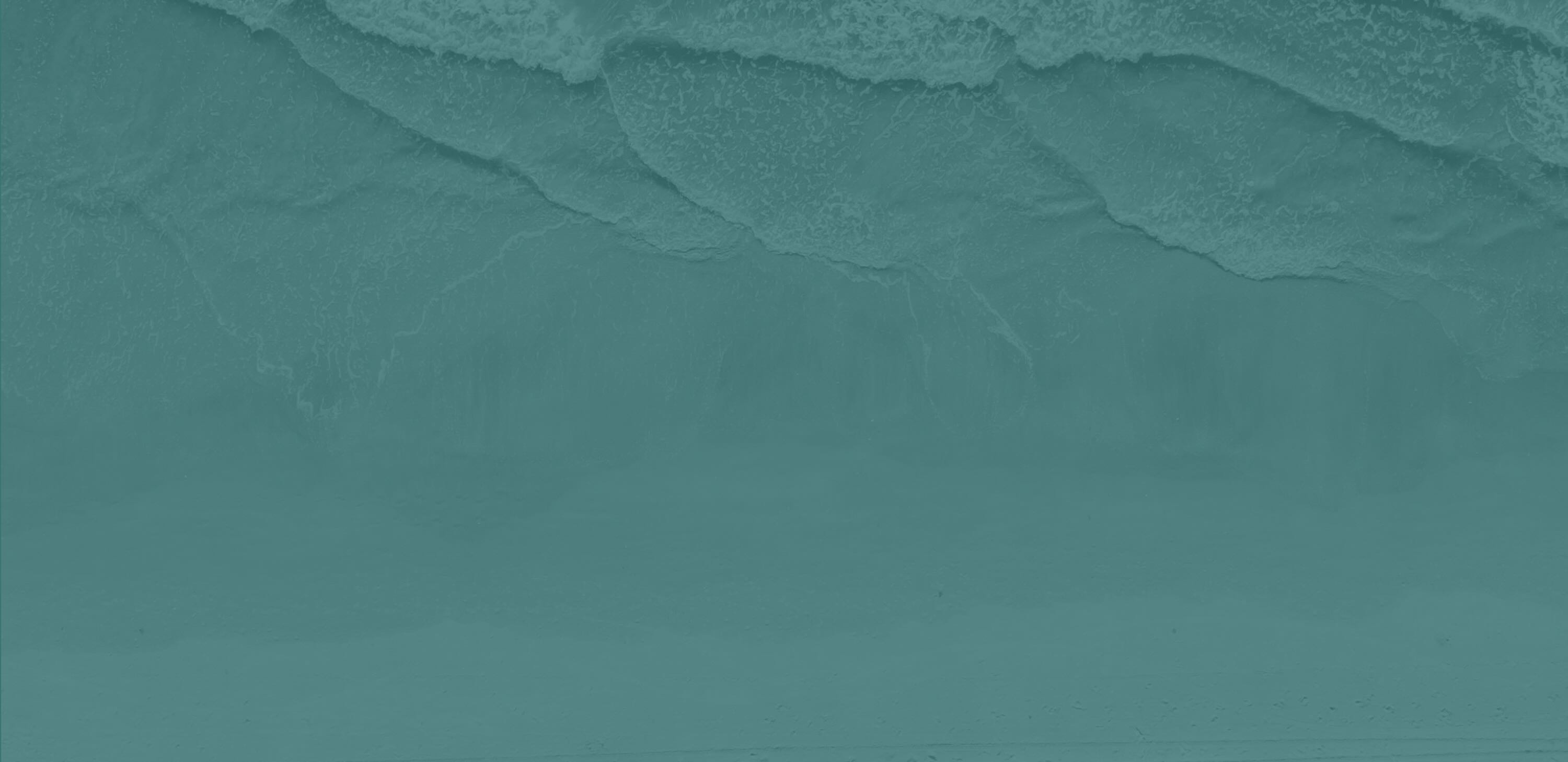 Aerial view of ocean waves washing onto a sandy beach.