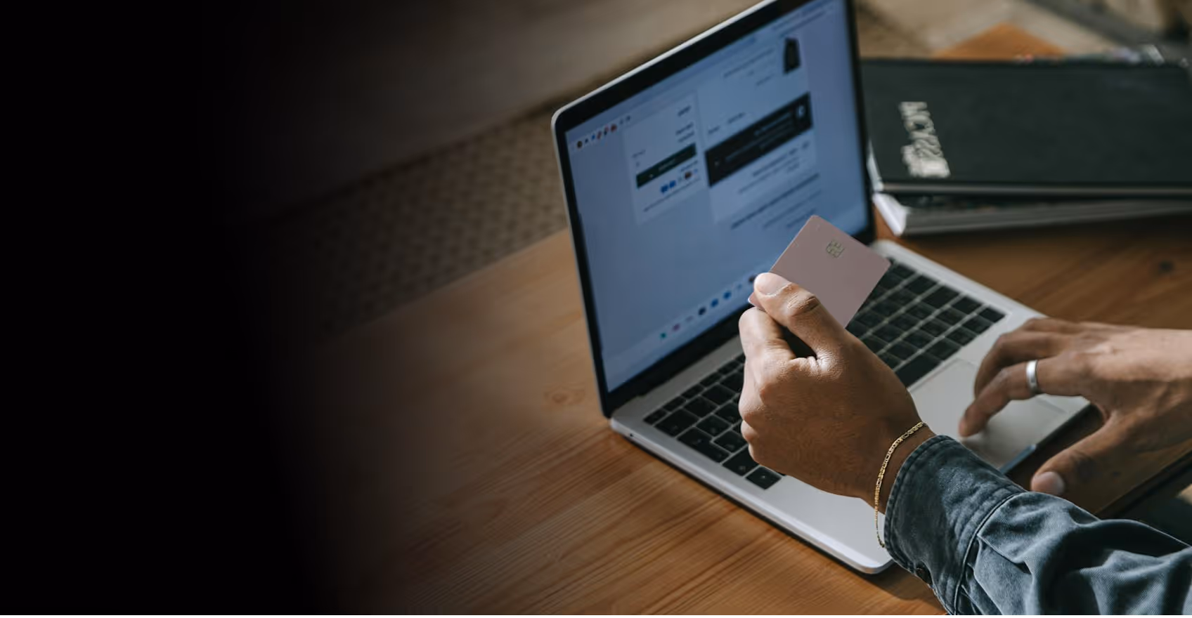 Person holding credit card and using laptop to make an online payment.