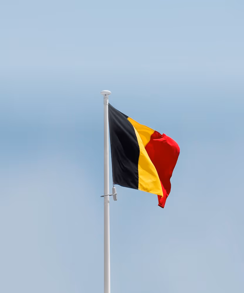 The Belgian national flag flying against a clear sky