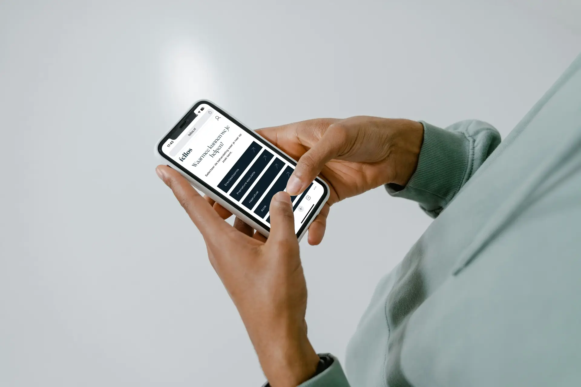 Man op telefoon bezoekt website Fellos