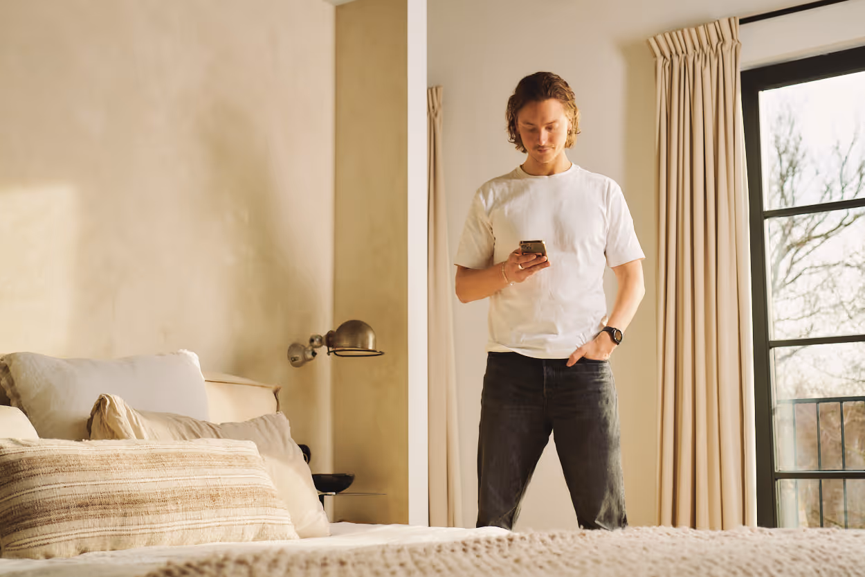 a man standing in a room using his phone