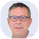 Porträt eine Mannes mit Brille und kurzem grauem Haar vor weißem Hintergrund.