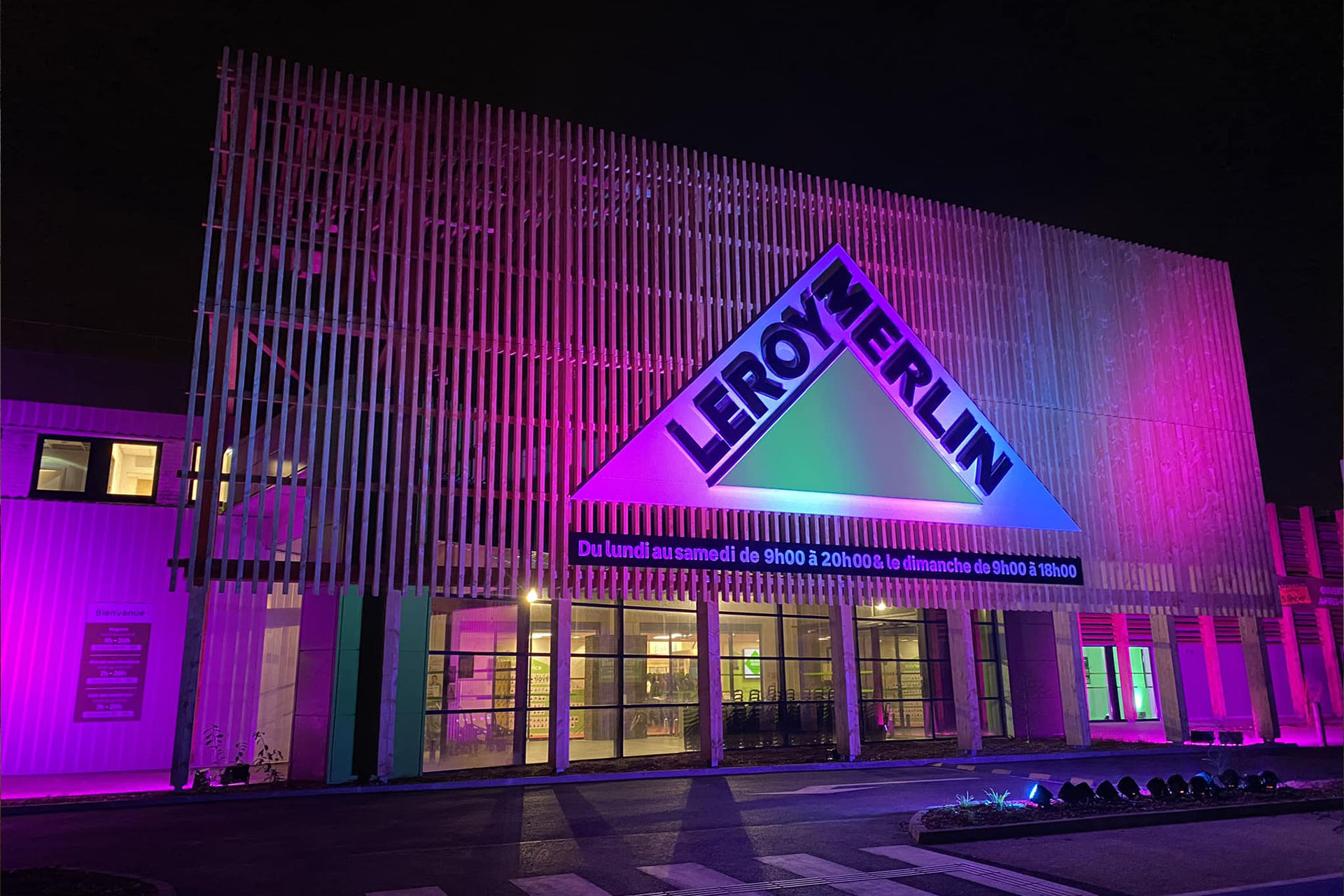 Façade du magasin Leroy Merlin illuminée de lumières violettes et bleues lors de son inauguration, décoration événementielle nocturne Wagnon Events