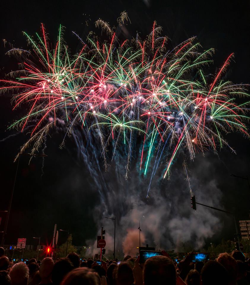 Éclats rouges verts bleus et dorés explosant au-dessus de la foule lors du spectacle pyrotechnique de la Fête Nationale à Strasbourg