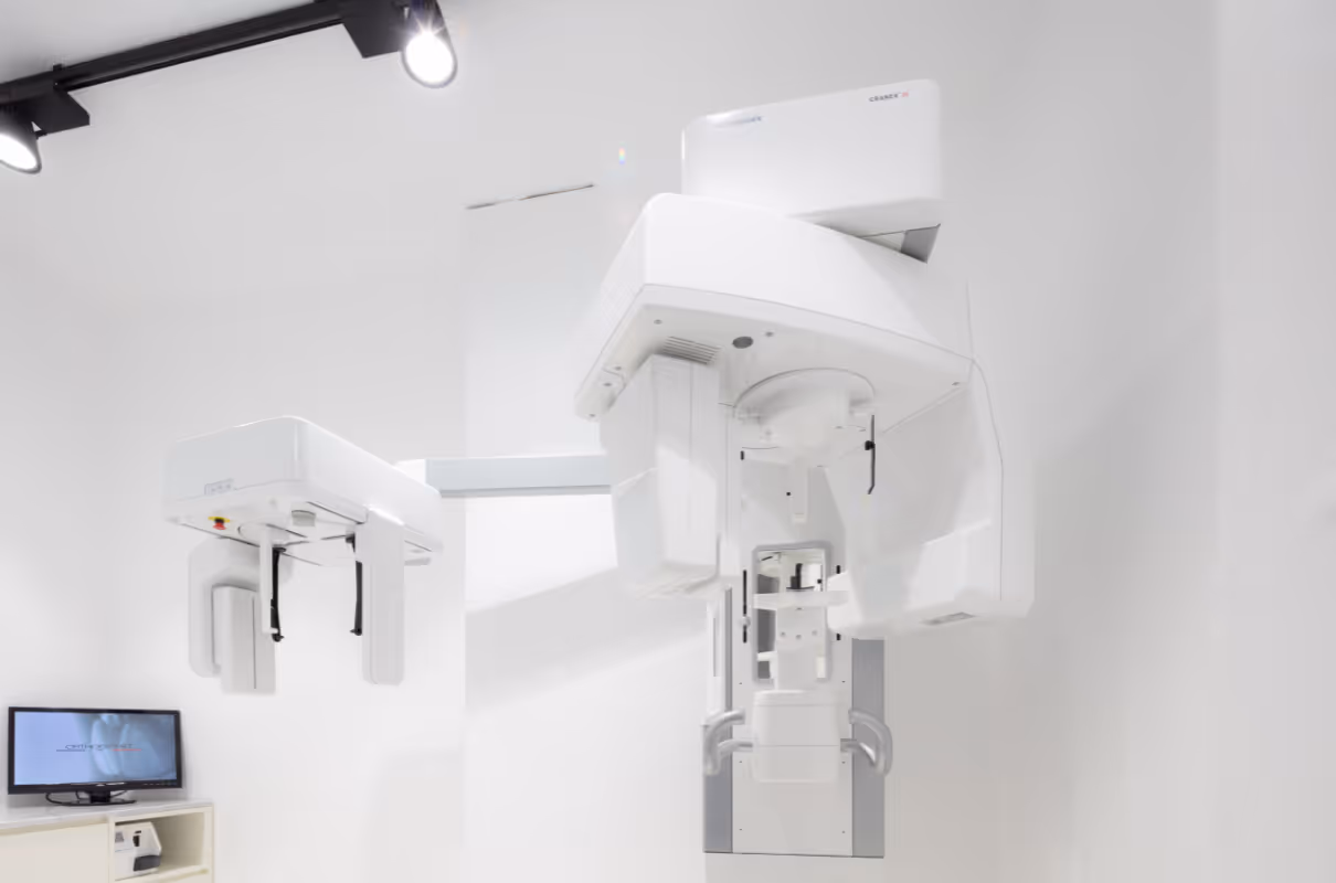 Appareil de radiologie dentaire moderne blanc dans une salle propre et bien éclairée.