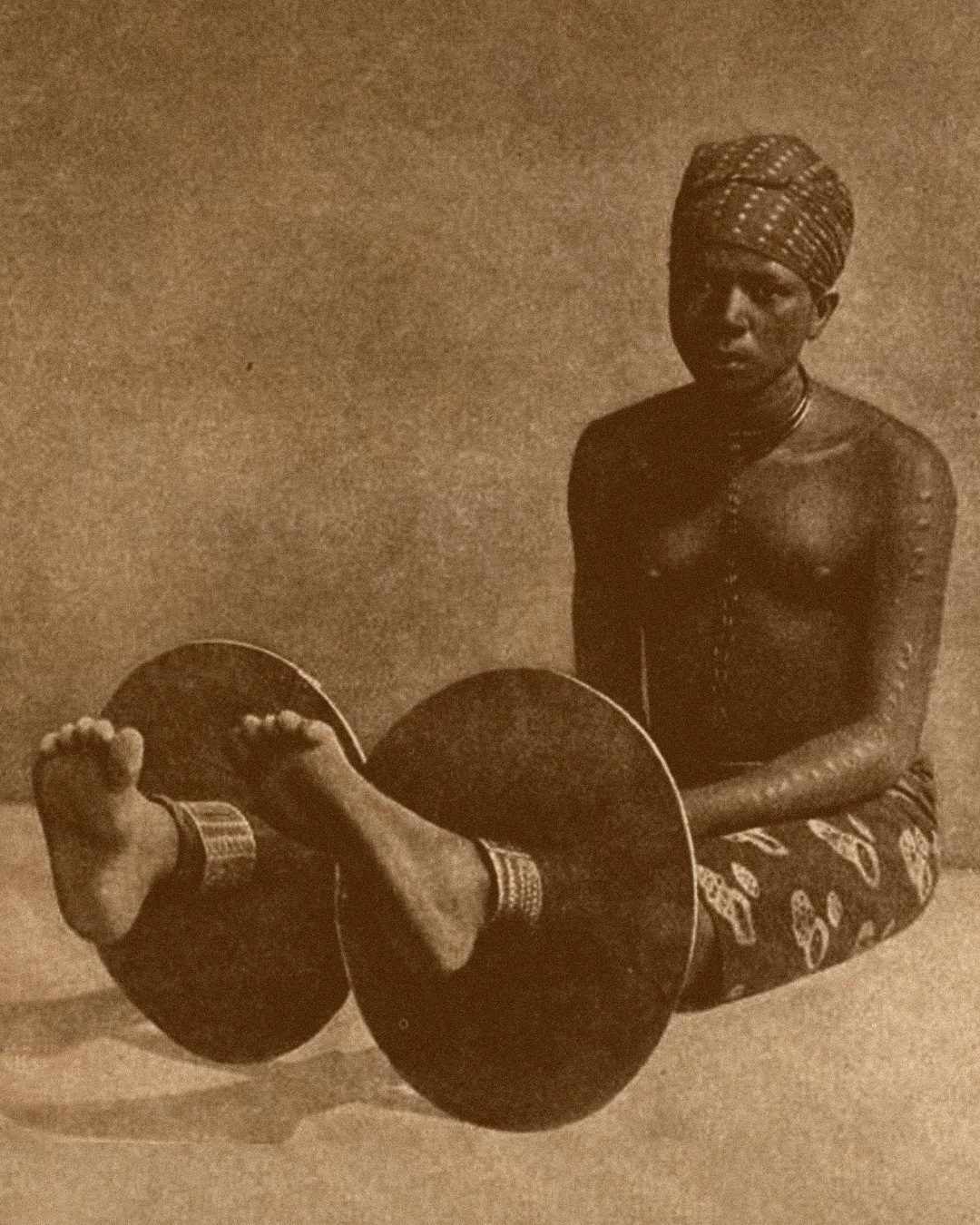 Woman seated wearing Igbo brass anklets — reference for Adala by ỌNWỤ Design