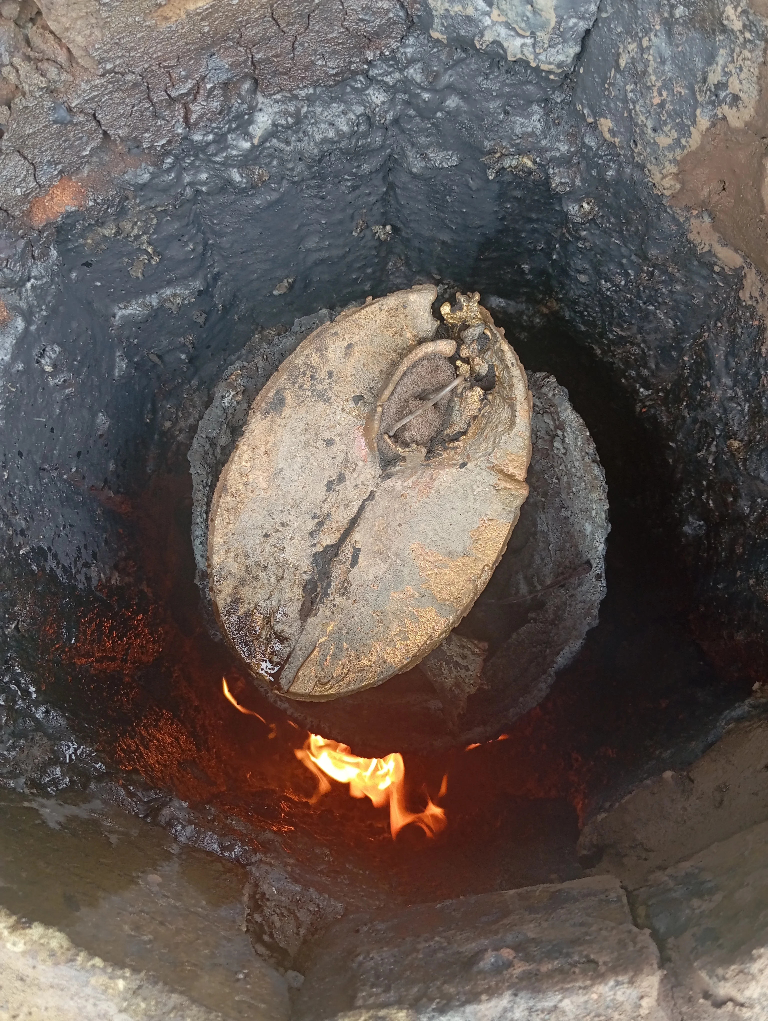 Circular sand mould with molten brass for Adala vase casting process
