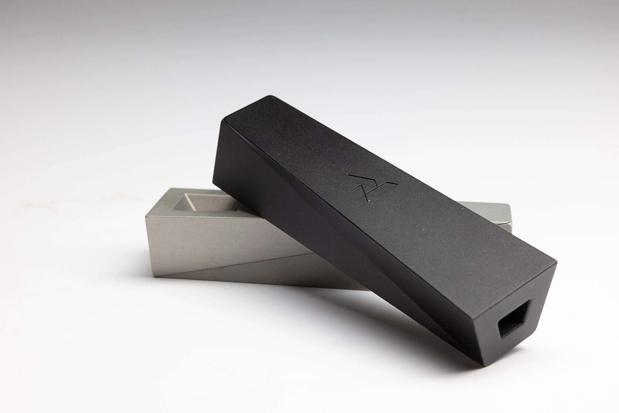 two Tempest pipes shown in black Abyss laying atop silver Mercury