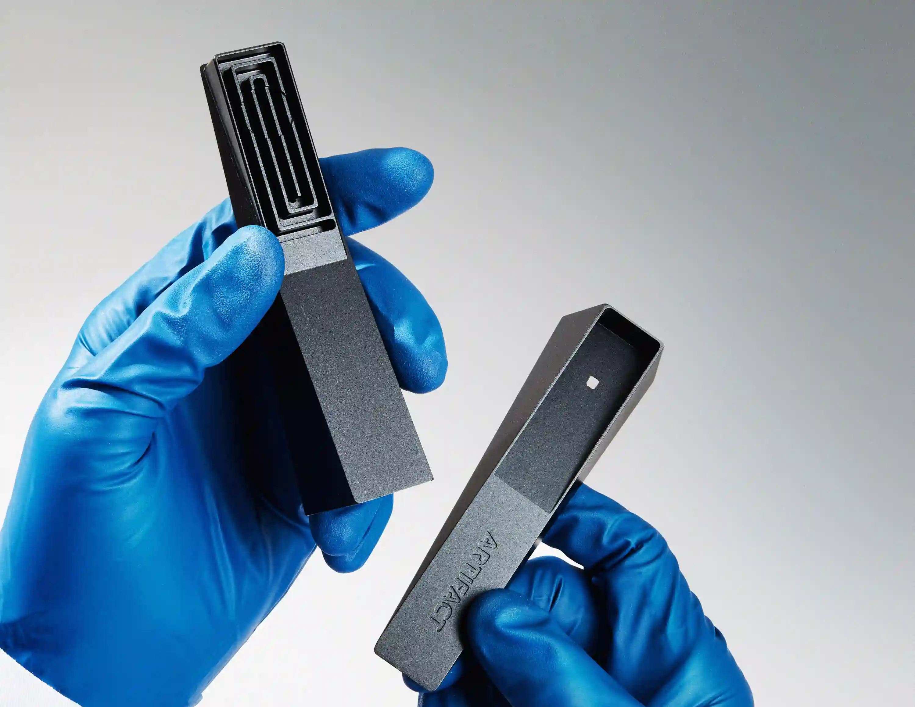 a gloved hand holding open the two halves of a modern aluminum smoking pipe called Tempest