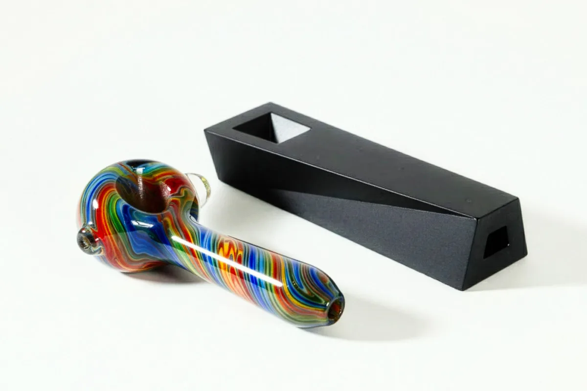 a classic glass spoon pipe next to a modern designer metal pipe called Tempest