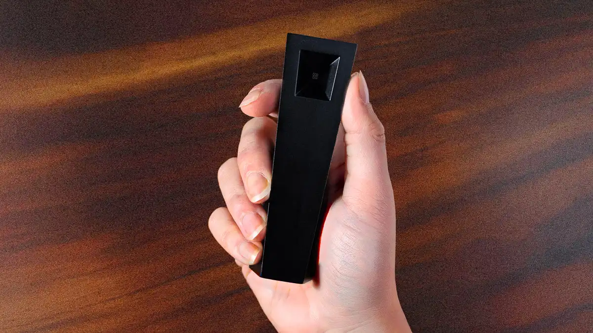 A persons hand holding a compact metal pipe