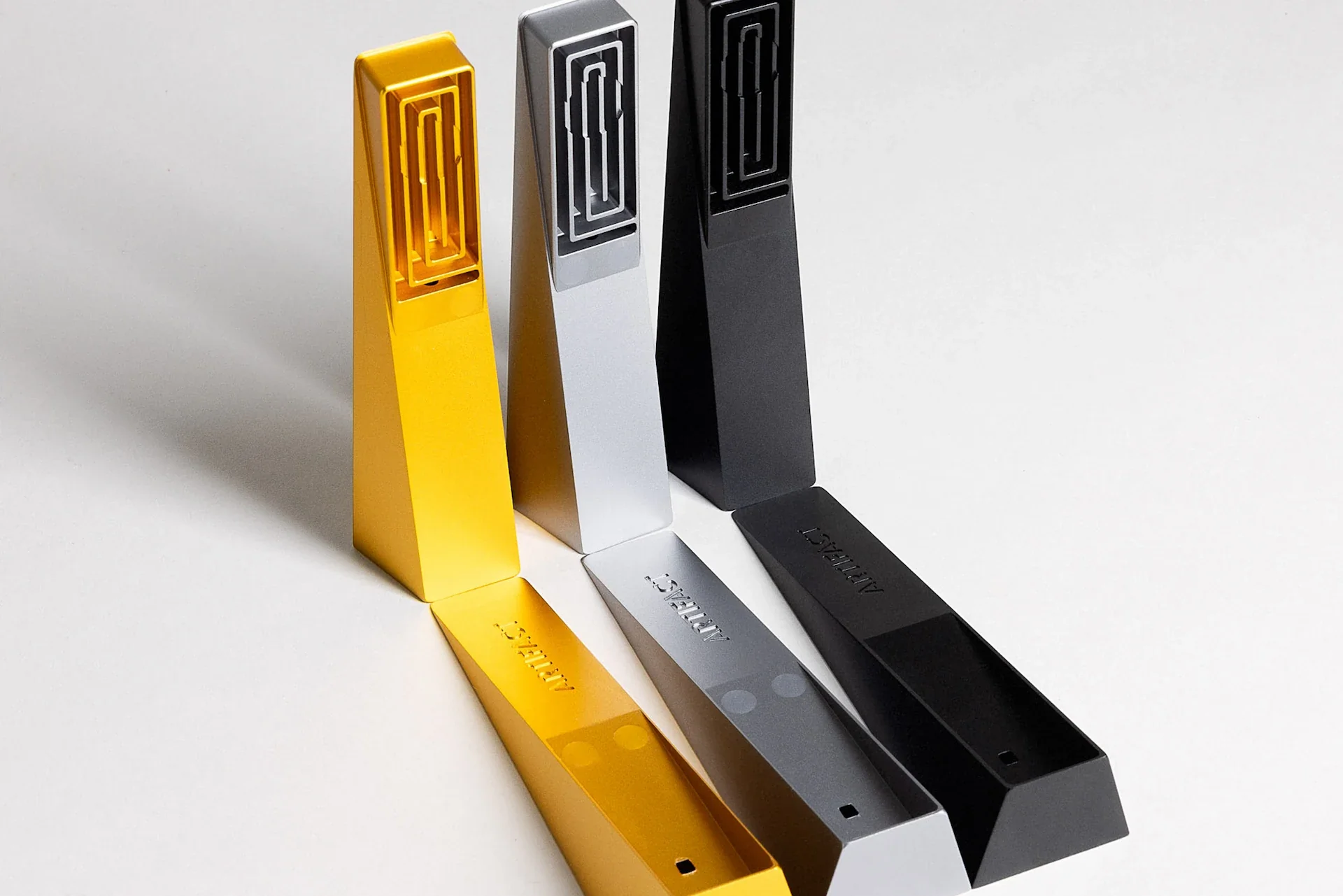 a trio of Tempest modern smoking pipes opened to highlight the cooling mechanism, shown in black abyss, gold radiance, and silver mercury
