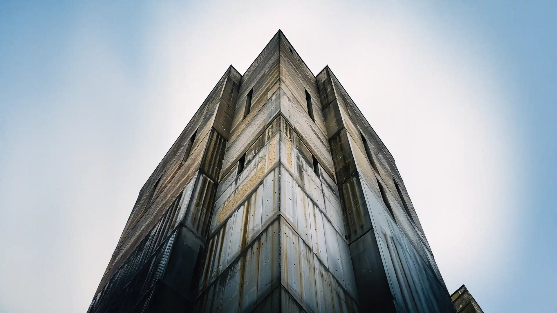 A towering brutalist building with sharp angles and poured concrete