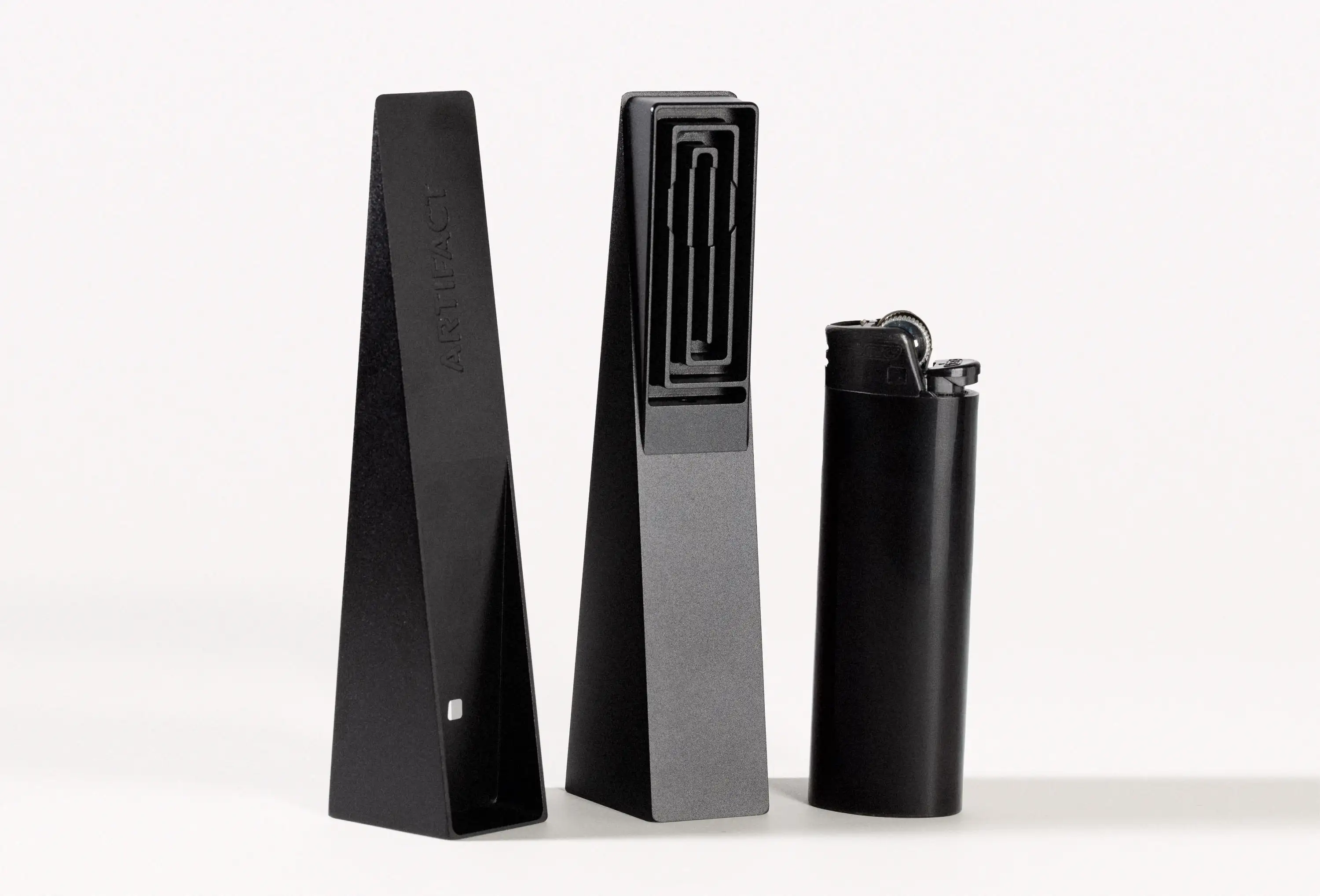 Black Tempest modern smoking pipe disassembled with lid and body beside a black lighter for scale