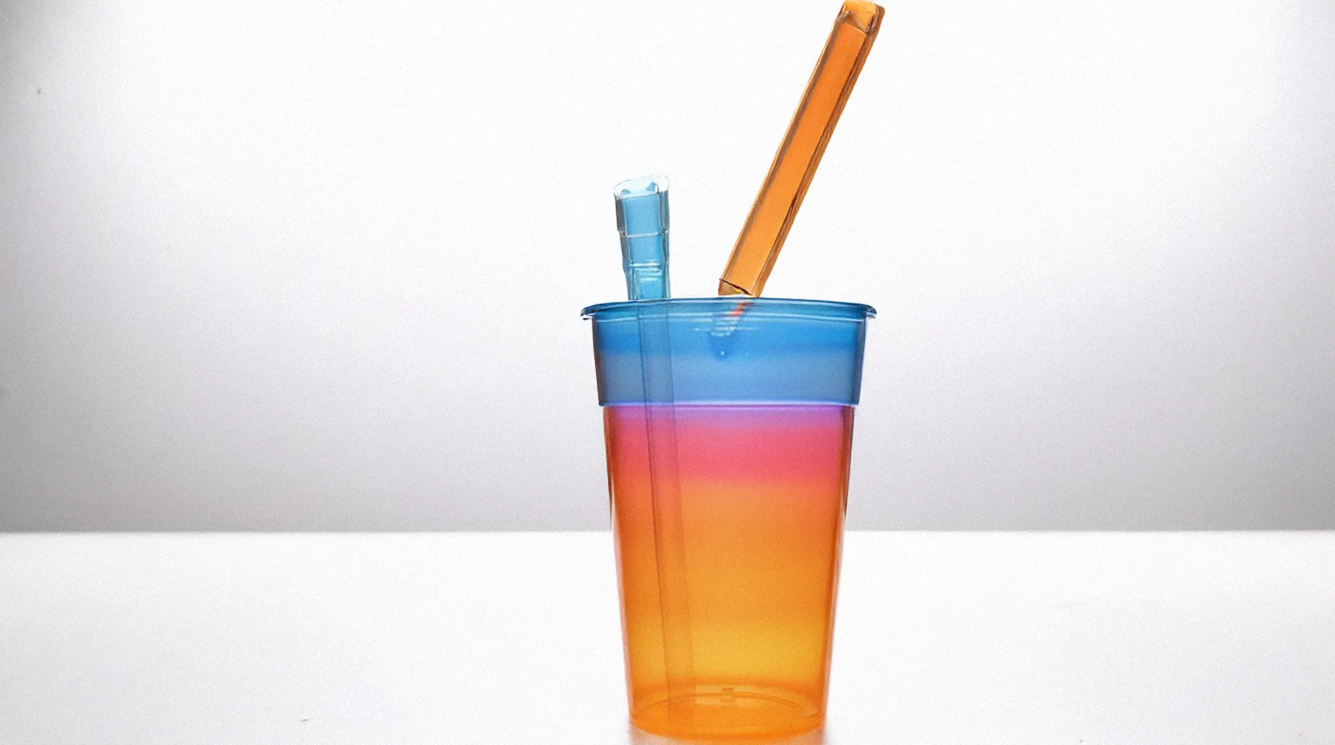 an artist created glass bong that is in the shape of a to-go plastic fast food cup on display in an art gallery