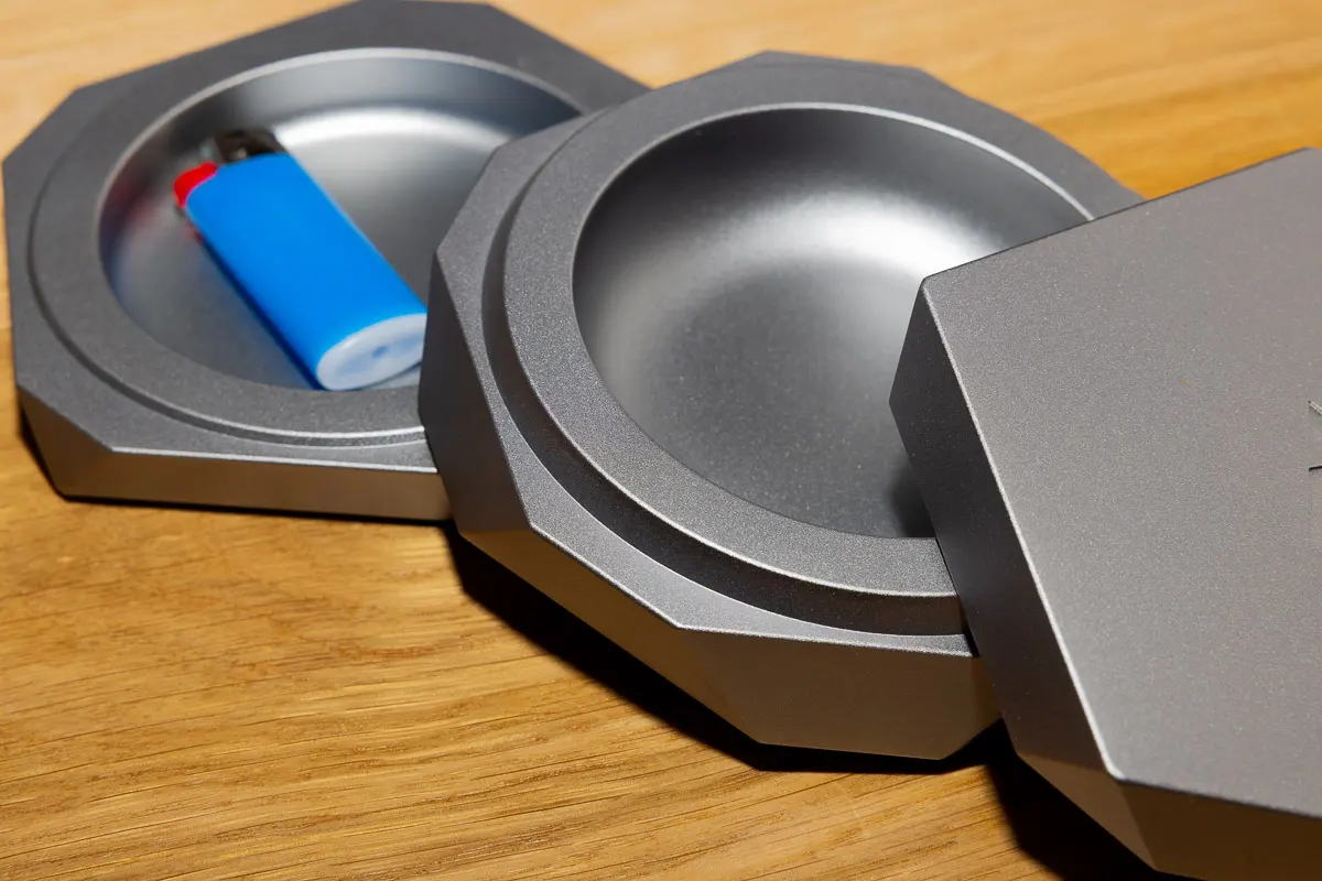 A designer metal ashtray with multiple compartments for storage