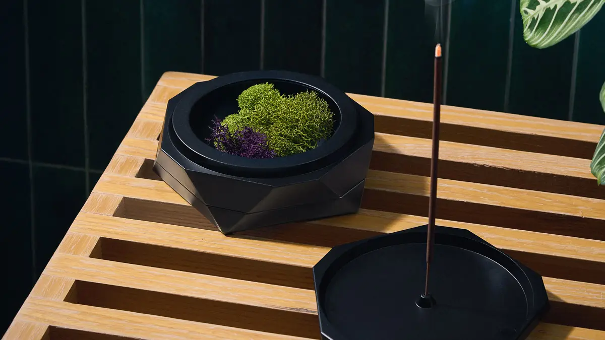 A Vesta designer ashtray in black Abyss with the lid open and incense stick mounted in the incense holder