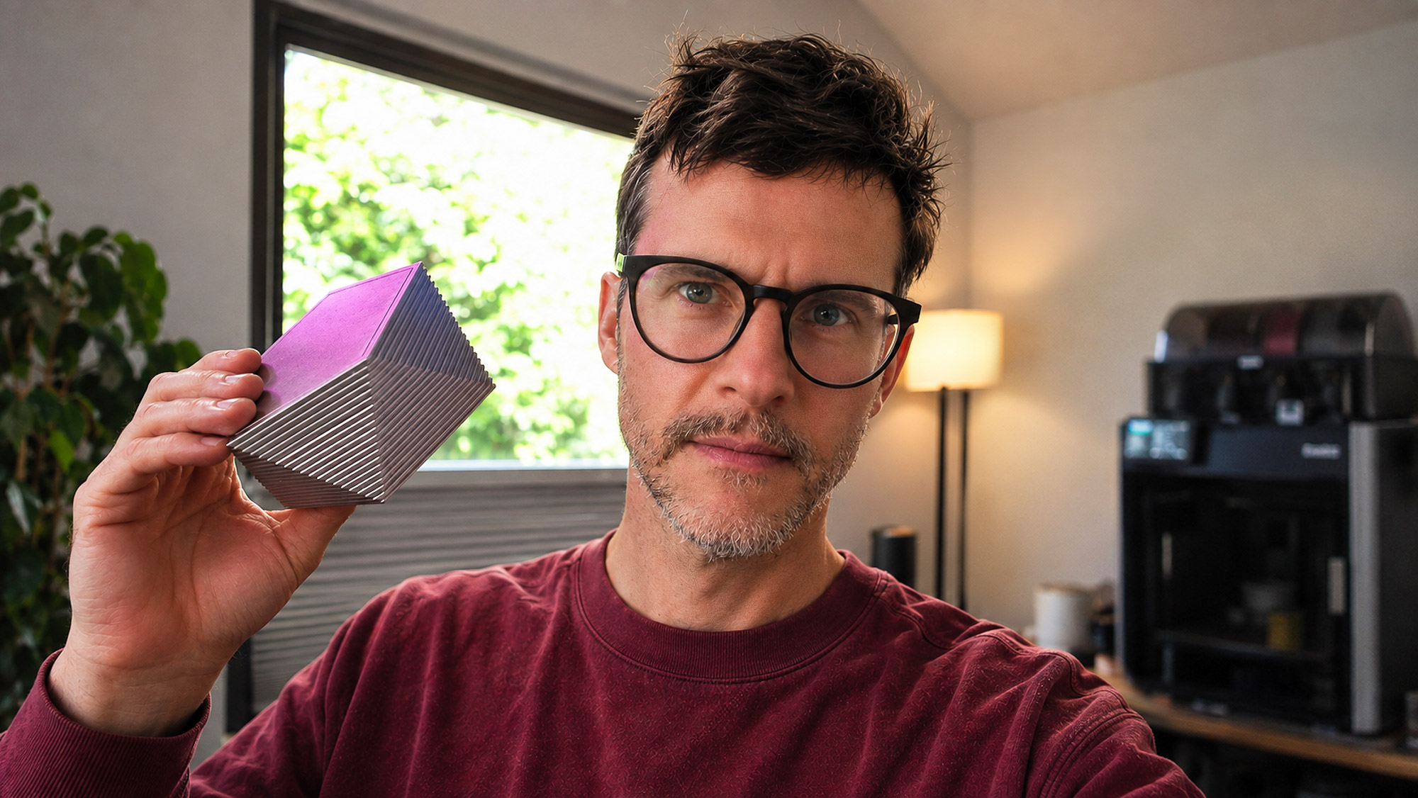 Ryan Rickett holding a ribbed metal prototype block in his home studio