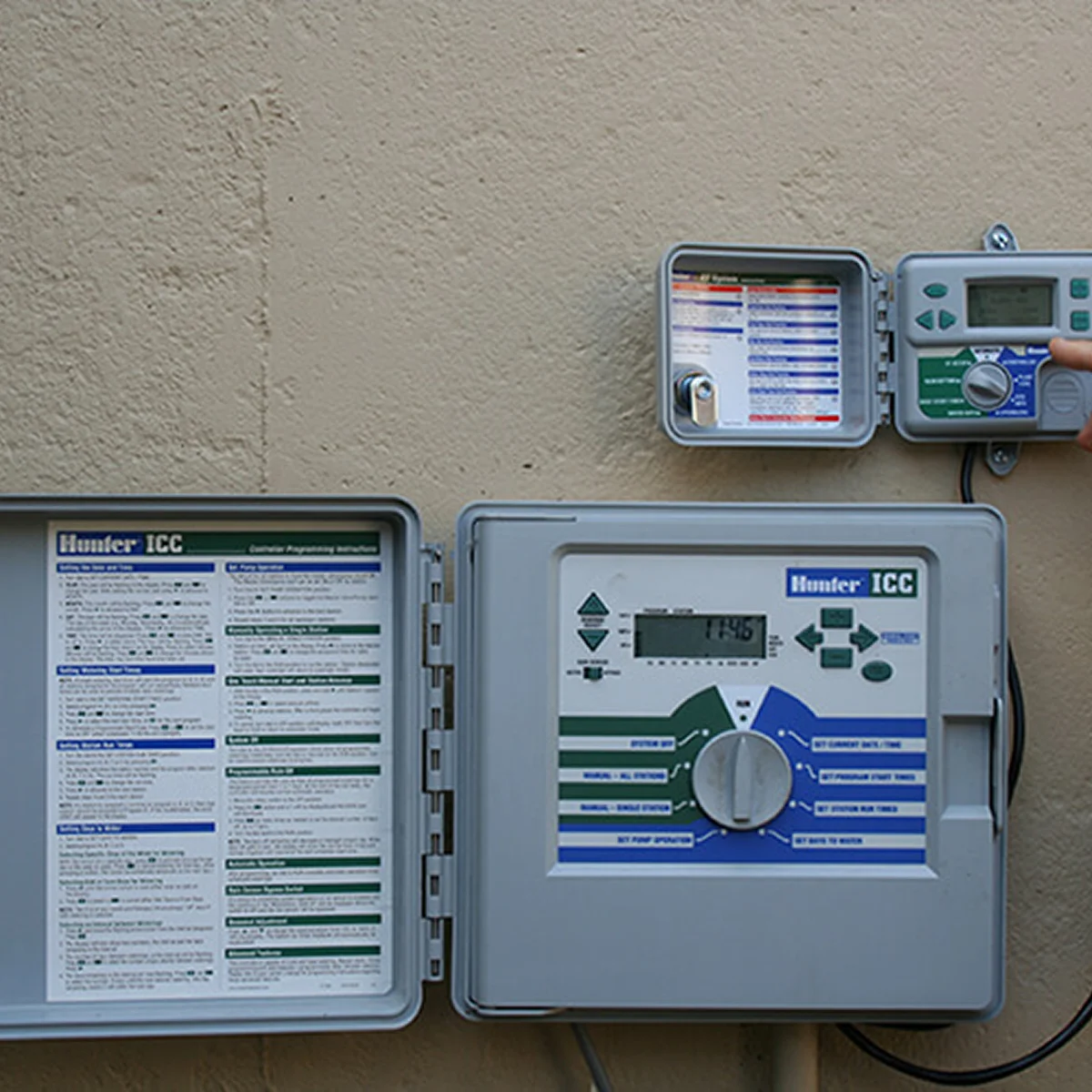 hand adjusting green irrigation controller timer