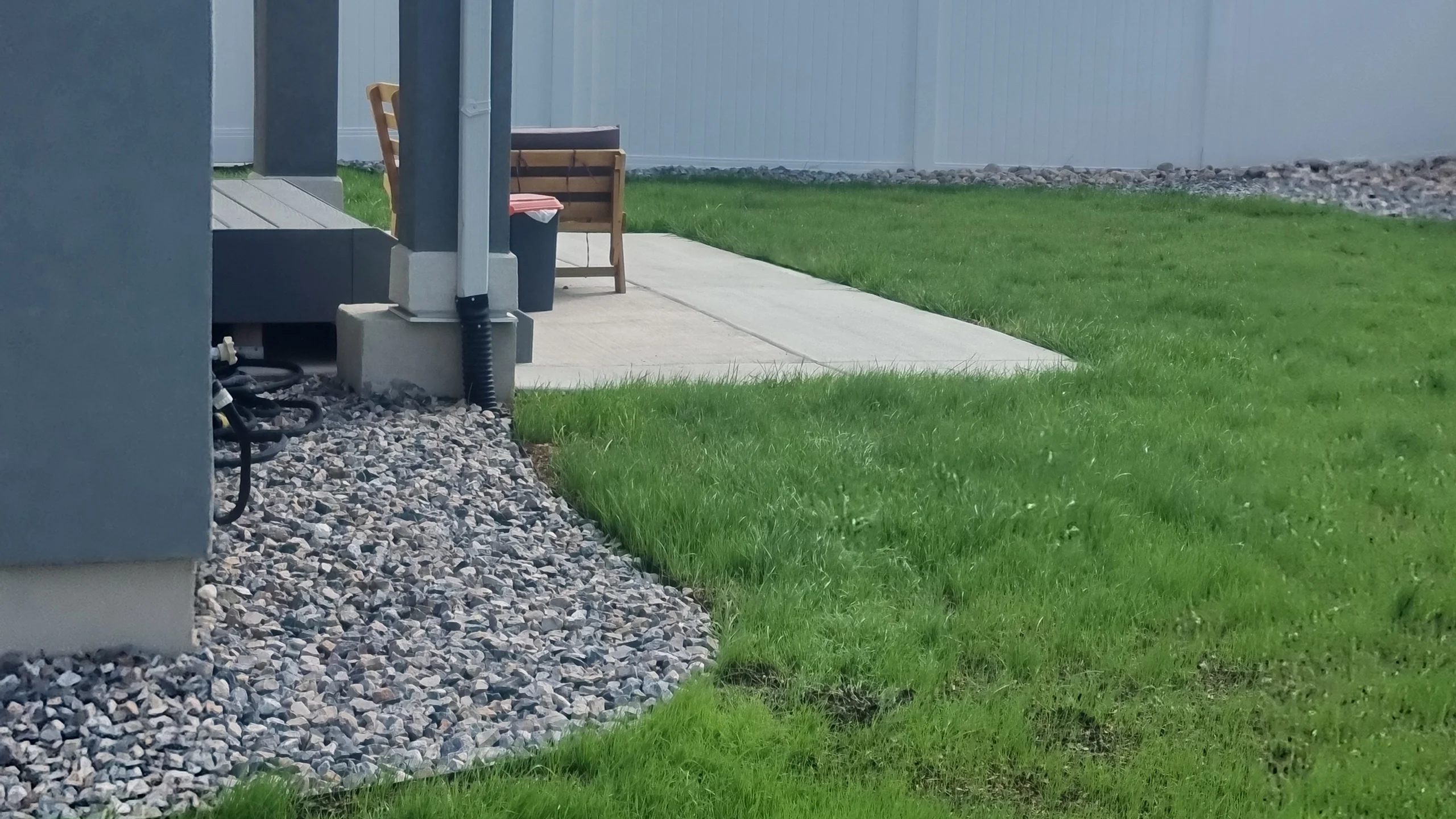 backyard green lawn gray rock edging patio