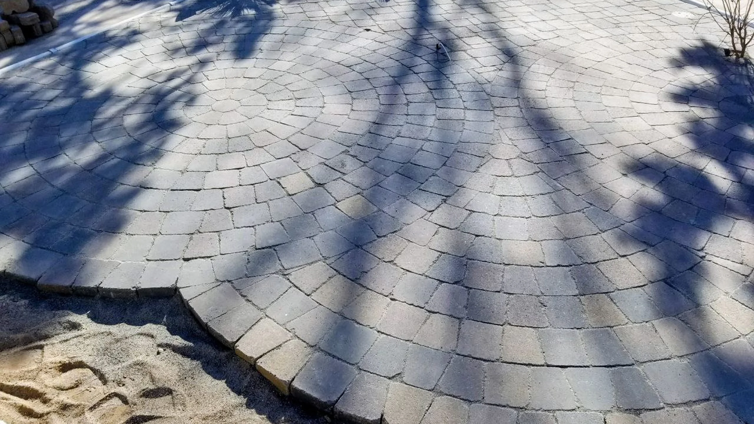 grey circular stone paver patio tree shadows
