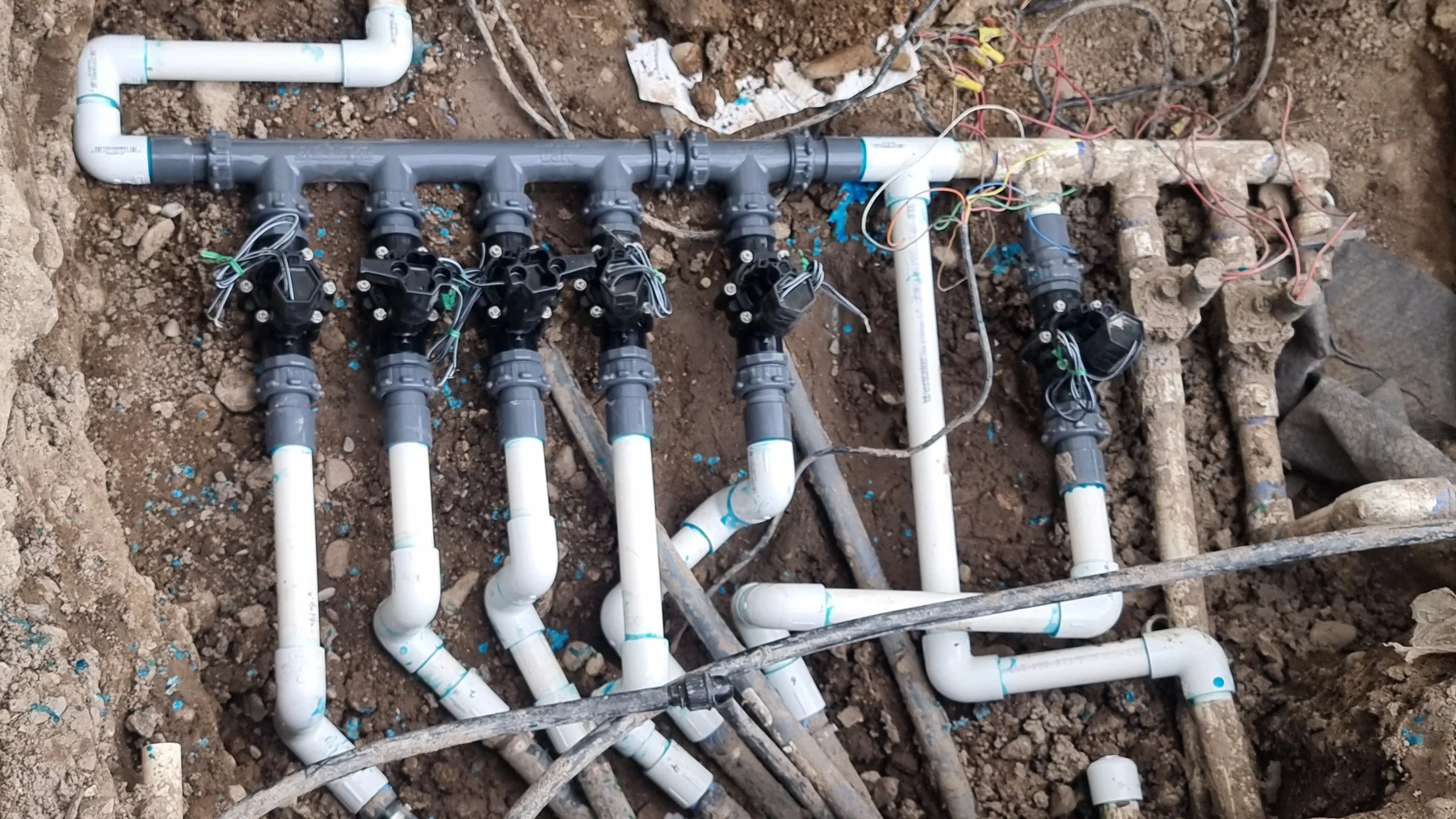 underground white pvc irrigation manifold with solenoid valves