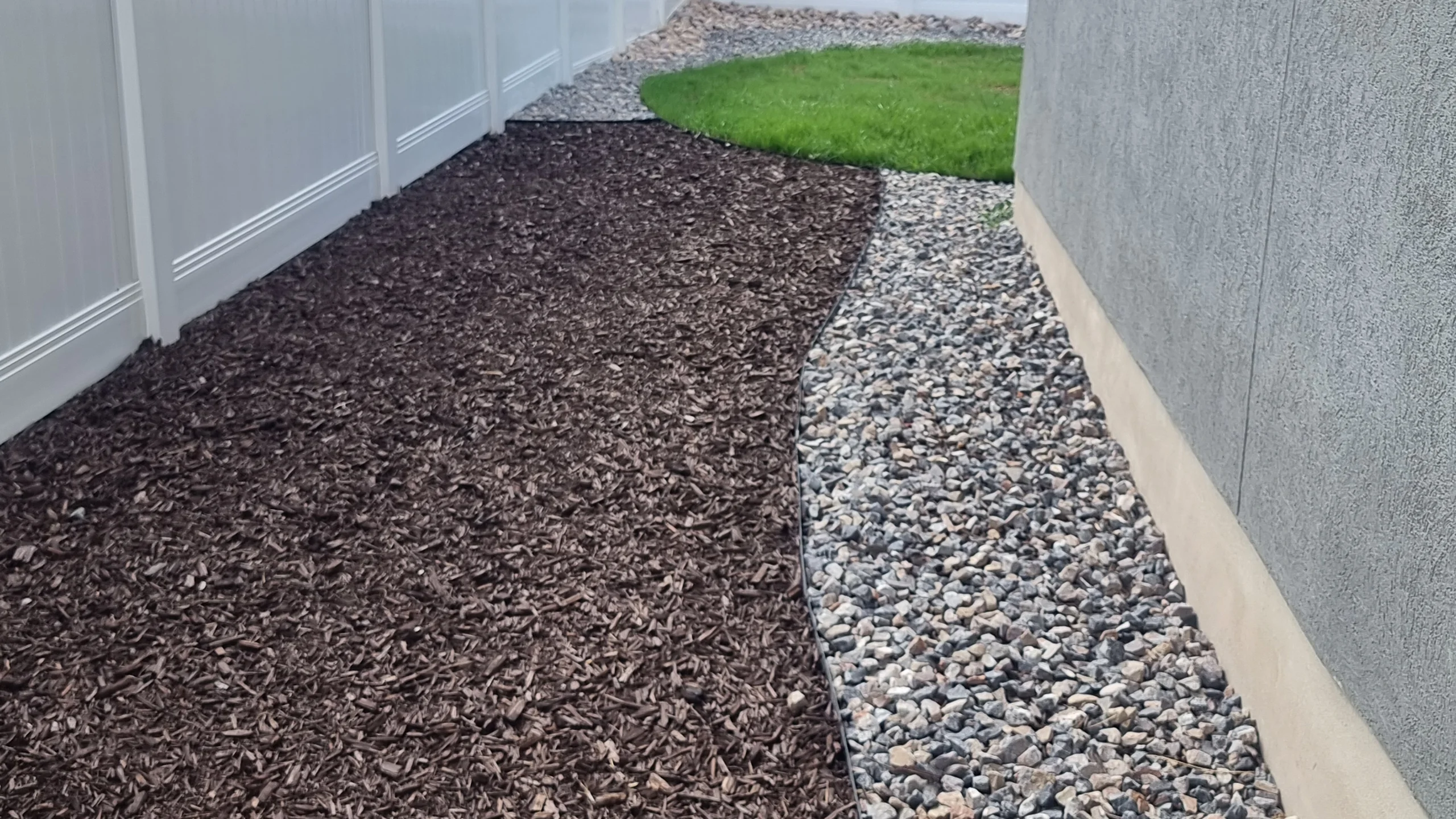 dark brown mulch gray river rock pathway