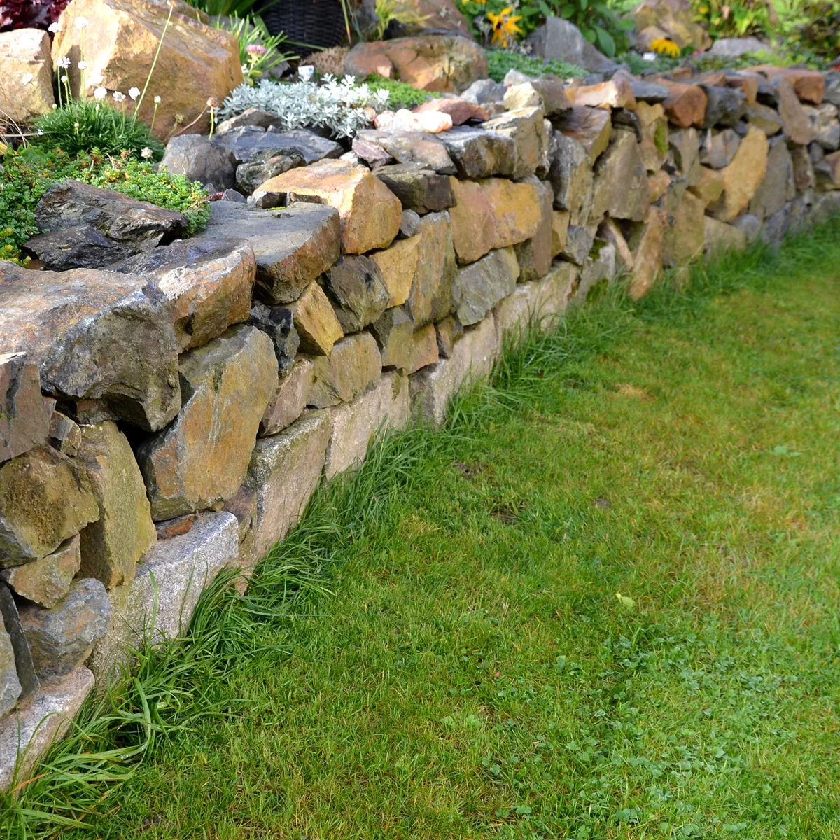 rustic-dry-stone-wall-green-lawn.webp