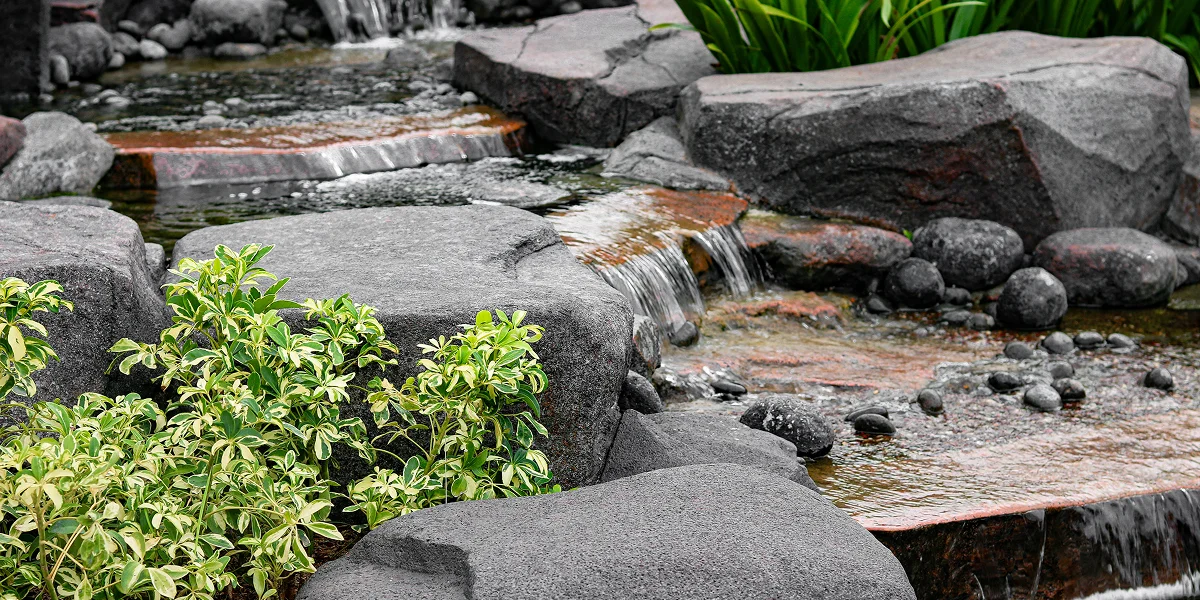 gray rock waterfall garden with green plants