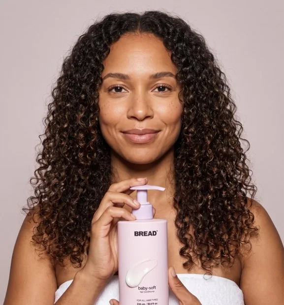 Long defined curls, holding a BREAD bottle
